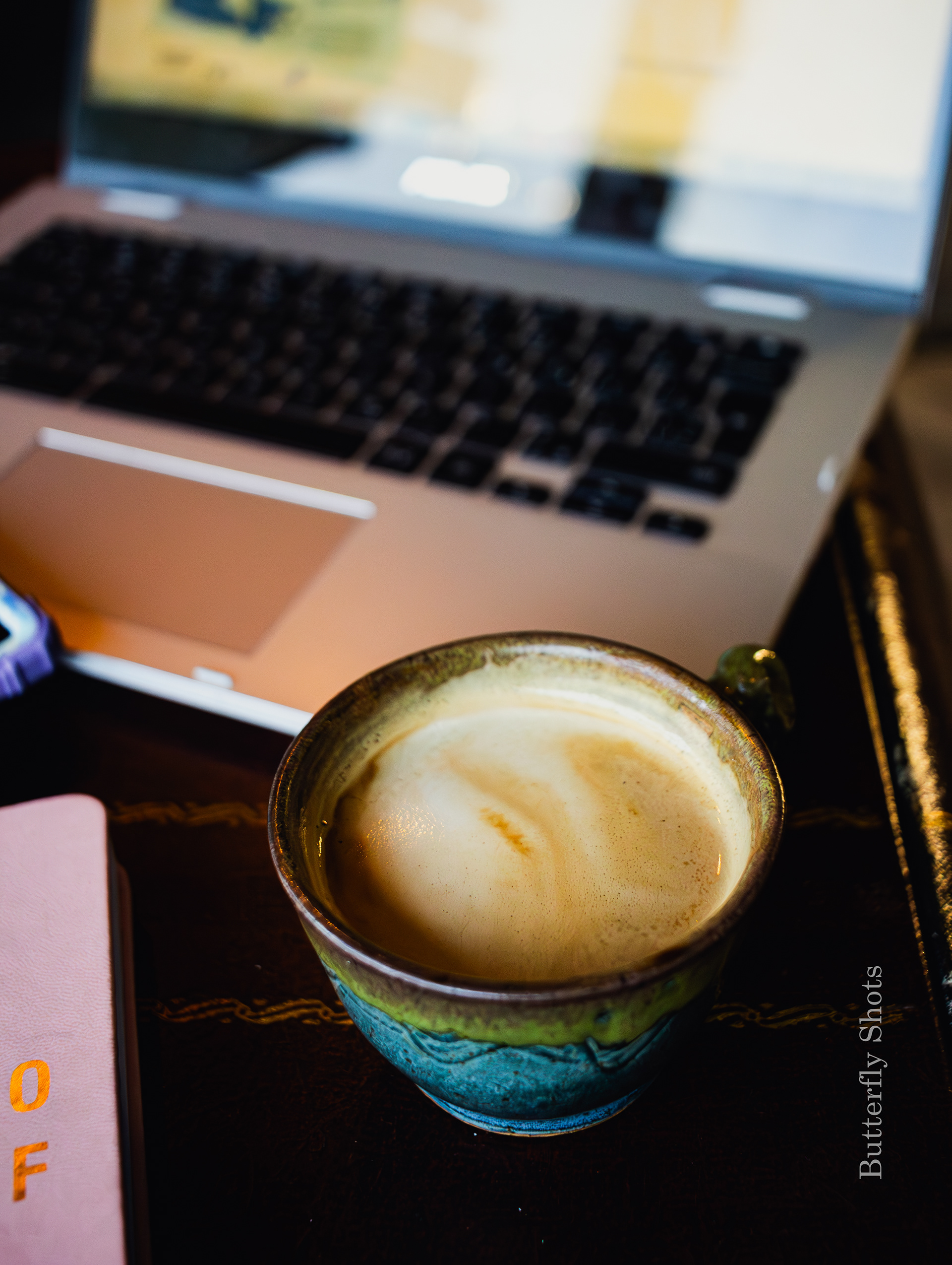Product photography (food photography) of a cortado coffee in front of a computer