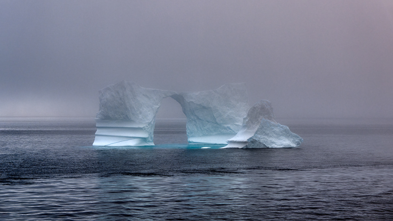 Während das Schiff den Eisberg umkreist sinkt erneut die Nebeldecke