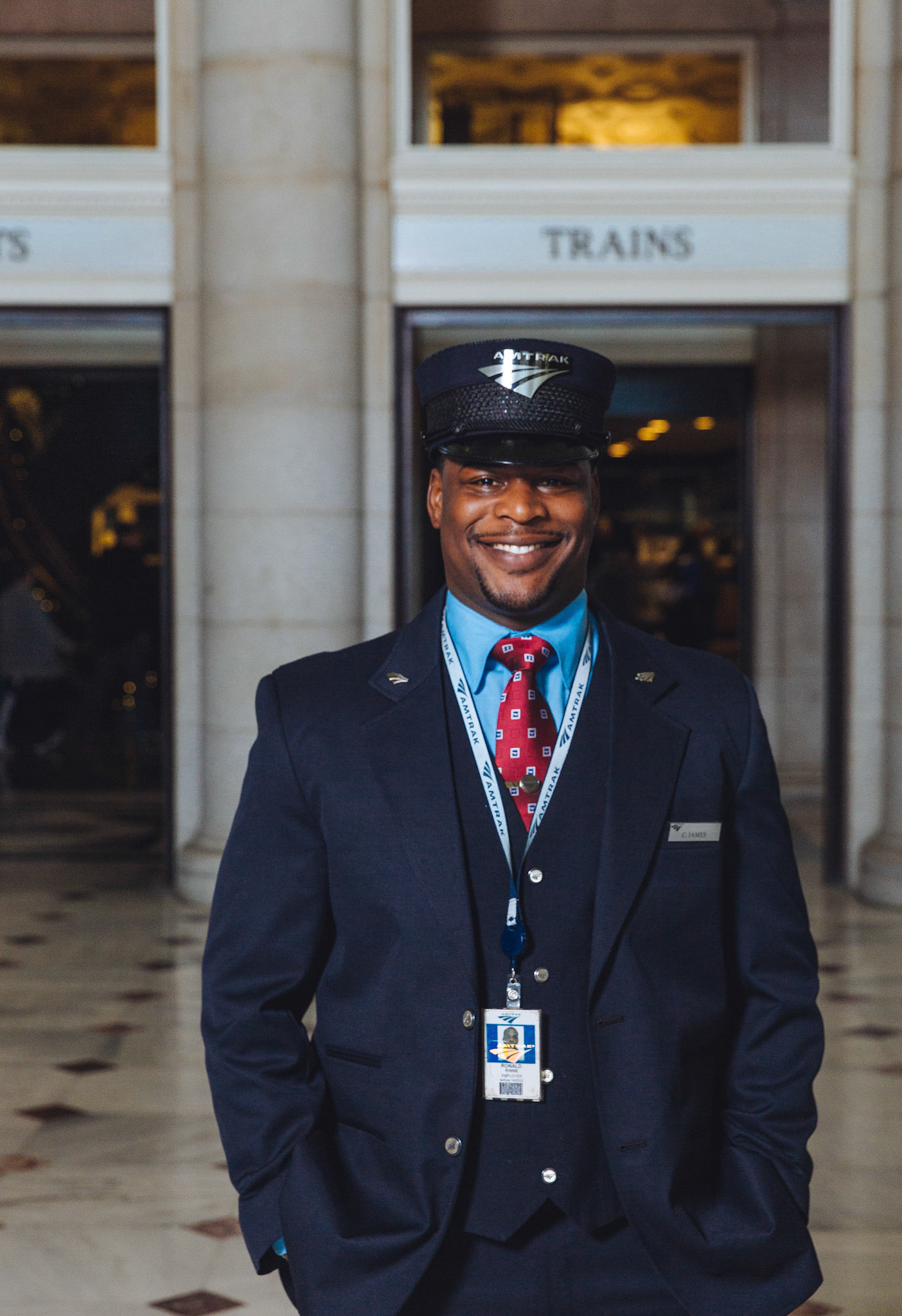 WAS, Washington, D.C., 2017, Amtrak Employees, Chuck Gomez, Union Station Great Hall, Washington Union Station, Passenger Concoursehttp://blog.amtrak.com/2014/01/amtrak-uniform/By 2006, it was back to navy blue again, this time with a military-inspired look. In 2000, we added color-coded epaulets to reflect specific job functions. An epaulet is a small strip of fabric on the shoulder. Today, assistant conductors wear a navy blue epaulet. Once promoted to a conductor, the epaulets change to navy blue with teal stripes.