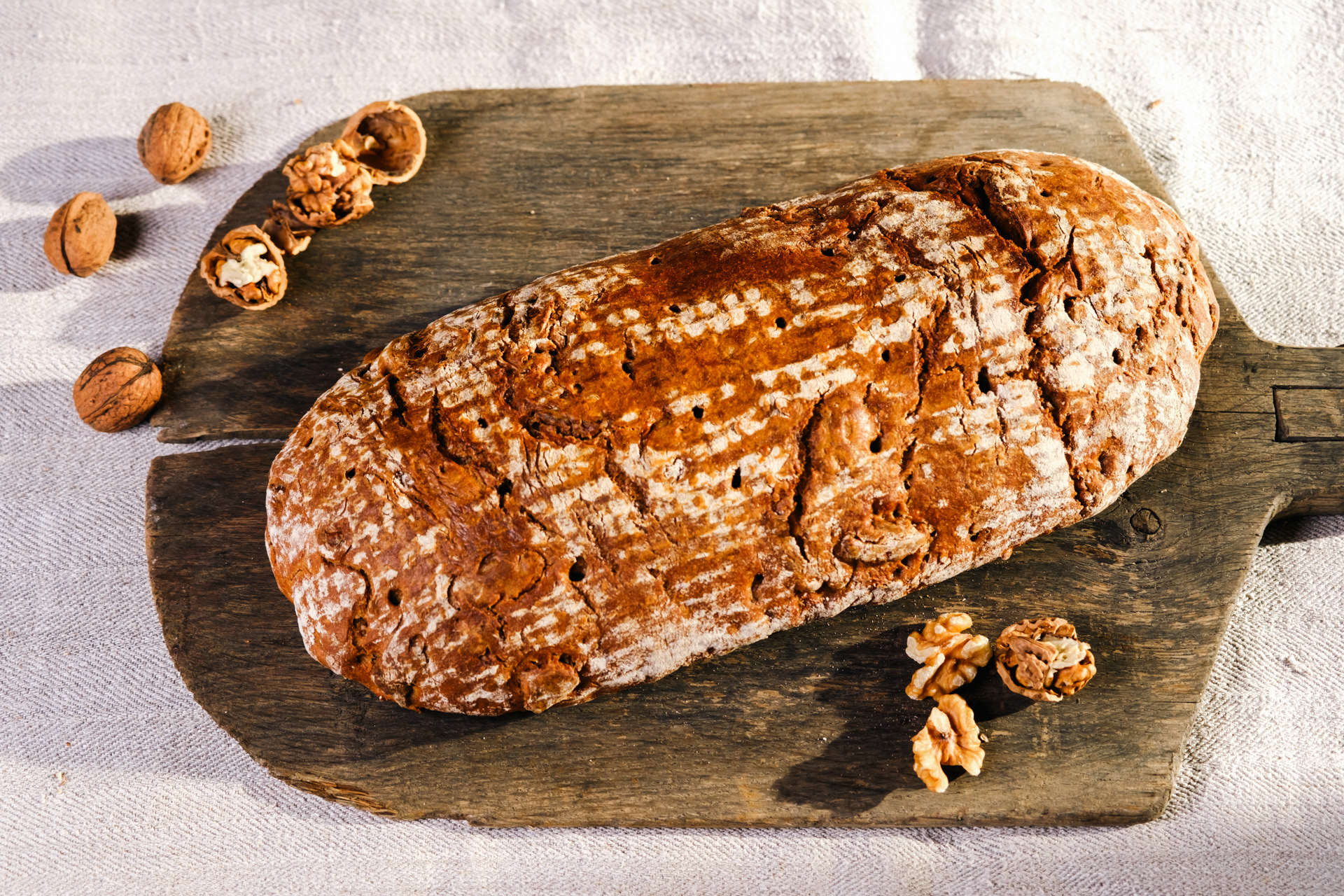 Brot auf einer alten Brotschaufel aus Holz. Produktfotografie von Georgi Sarkezi