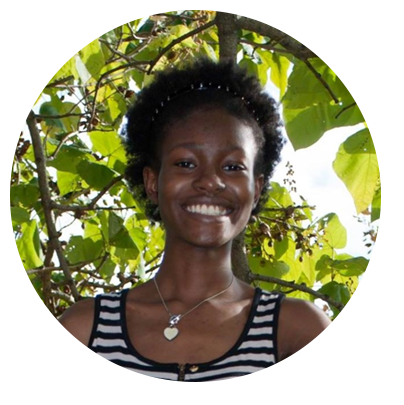 Circle-shaped photo of a black woman in a dress smiling in front of a lush green scenery