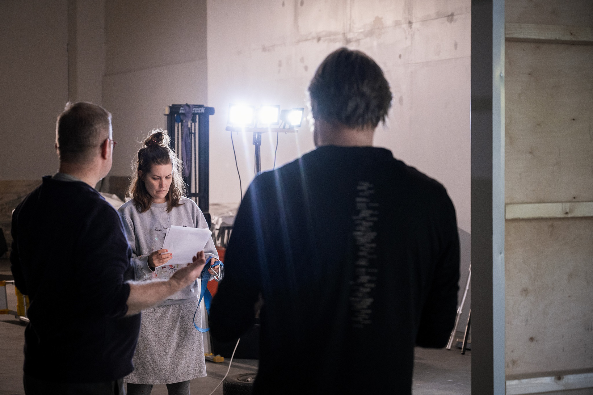 Janne Laine, Emmi Kallio ja Sampsa Virkajärvi valmistautuvat Laura Liljan teoksen ripustukseen.