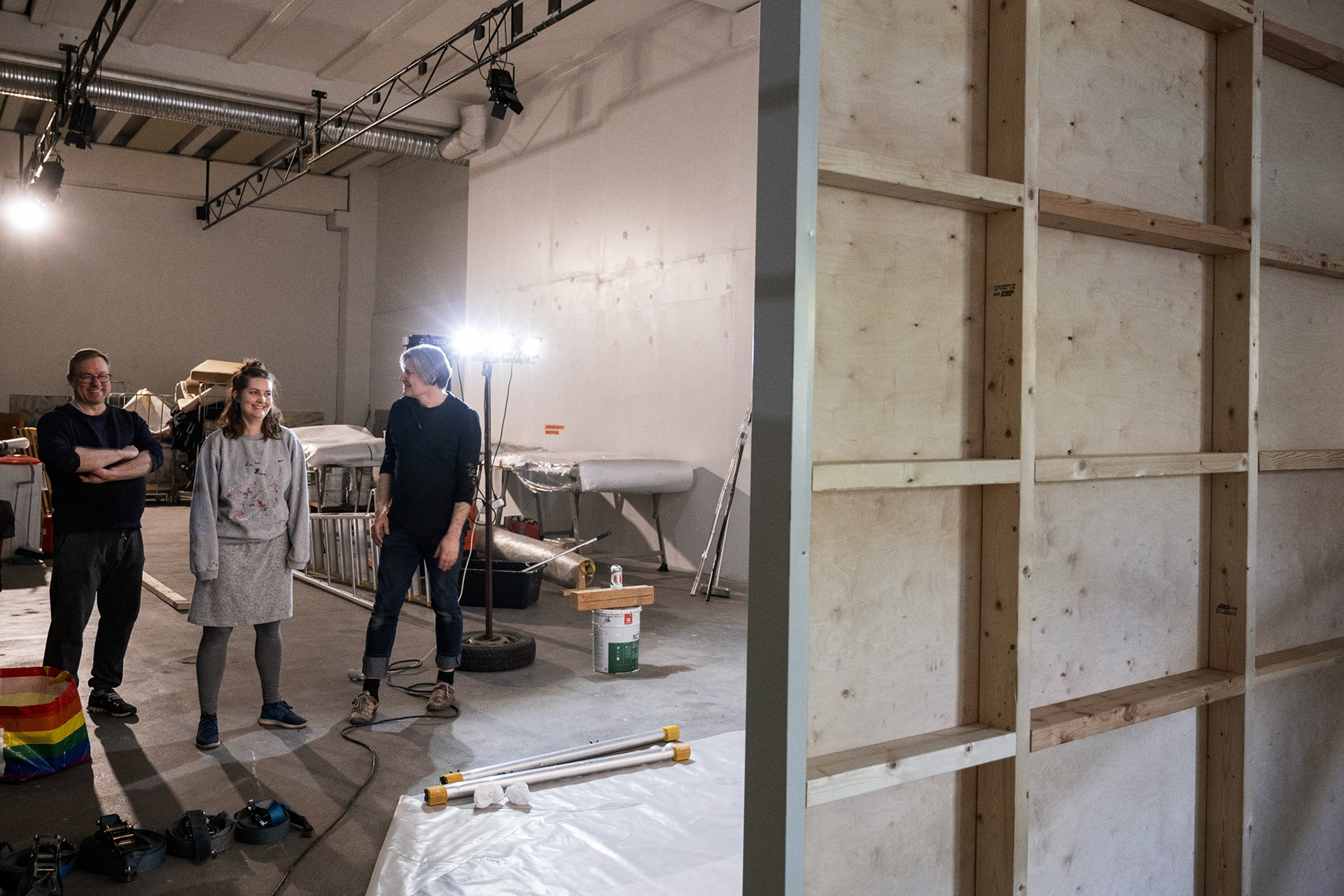 Janne Laine, Emmi Kallio ja Sampsa Virkajärvi valmistautuvat Laura Liljan teoksen ripustukseen.