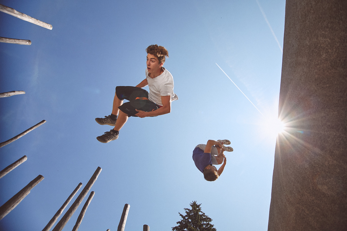 Parkour Sportler im Salto in der Luft, springen von eienr Mauer