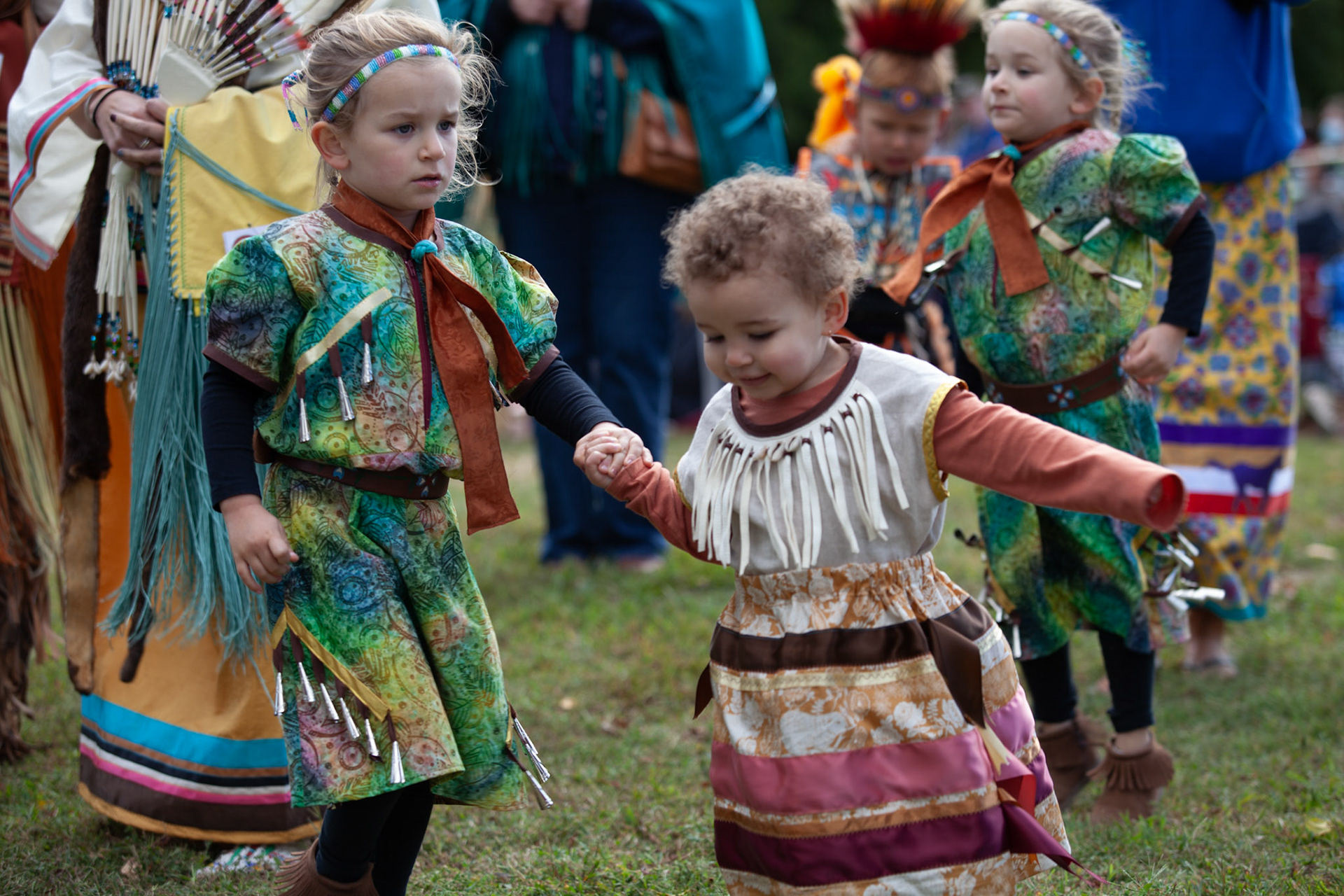 Young children in regalia enjoying the dancing.