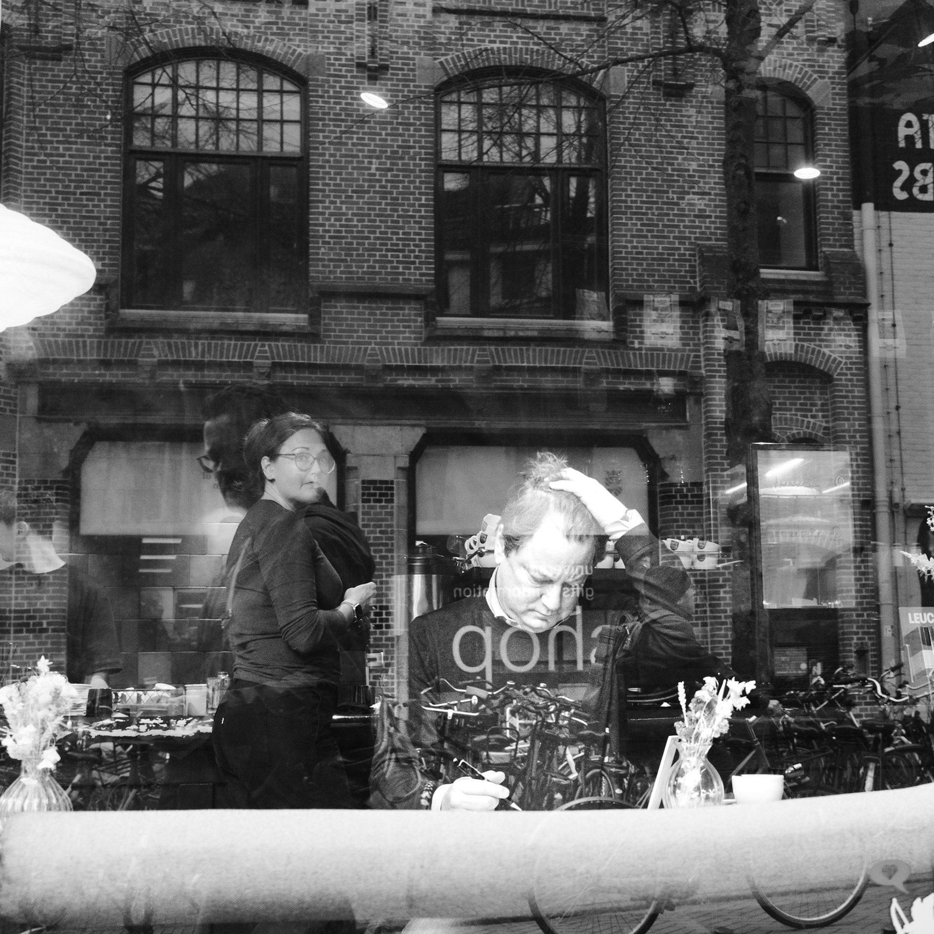 Zwart-wit door-raam: zelfreflectie in alledaagse scène.