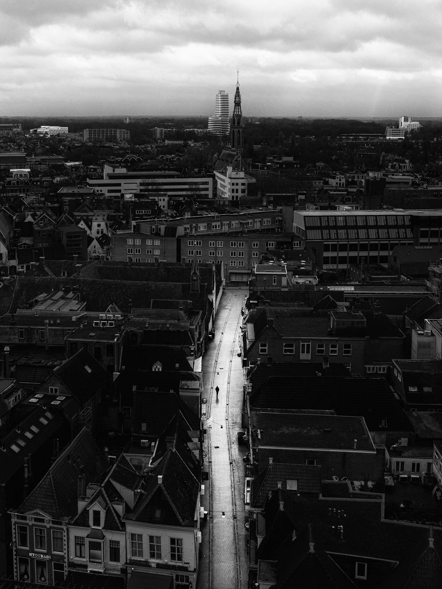 Urban solitude: eenzame wandelaar loopt door lege straat in Groningen.
