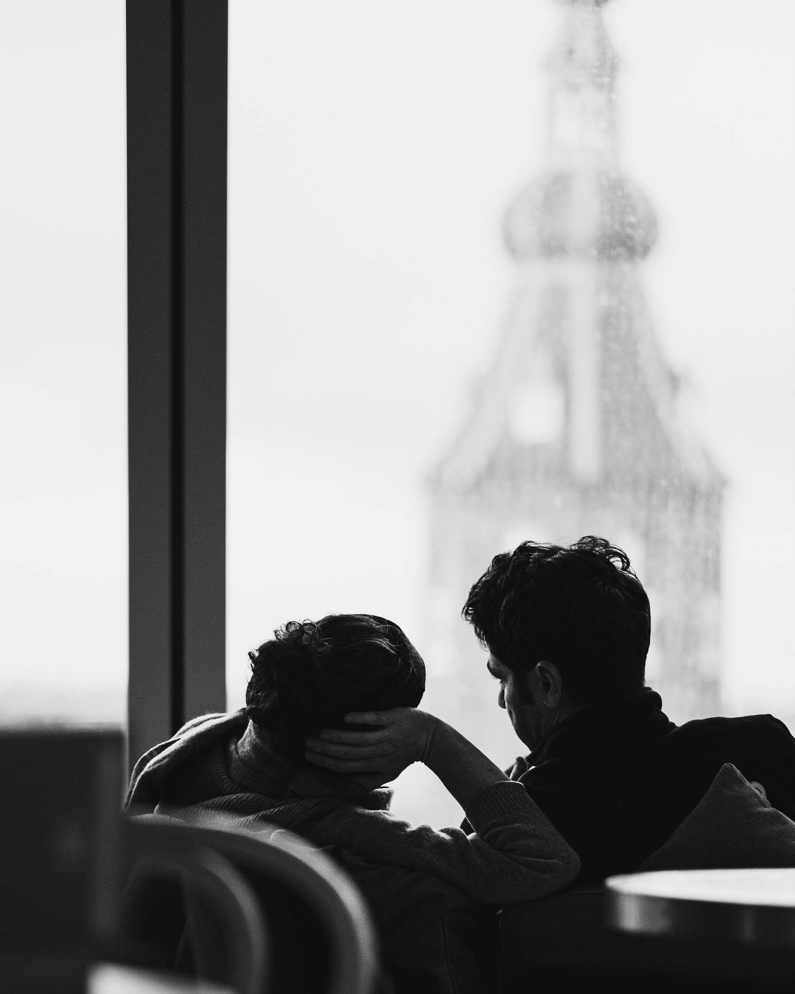 Intieme blik door regenraam: toren fluistert geheimen.