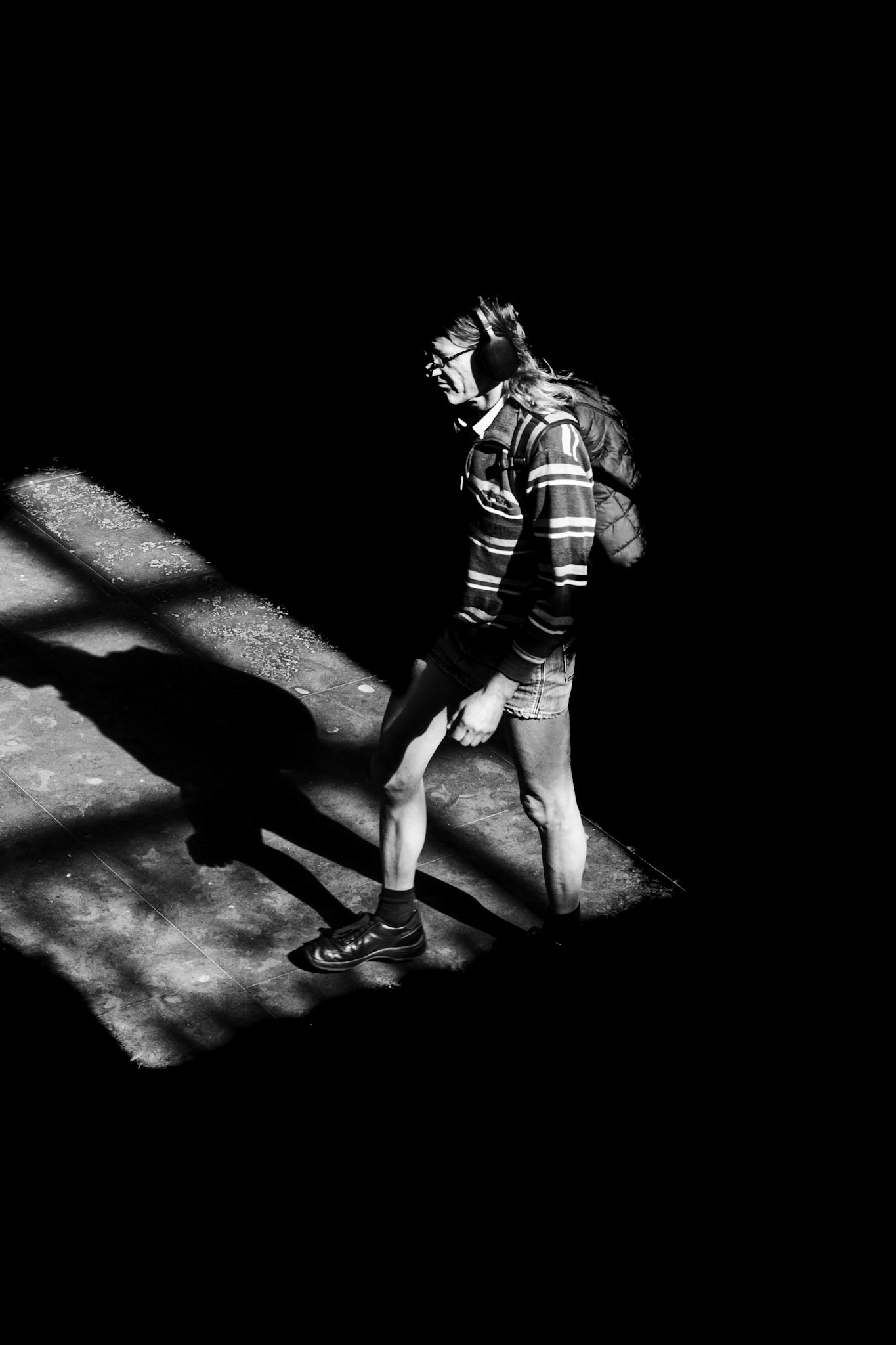 Geheimzinnige wandelaar, schaduw danst in rasterlicht.