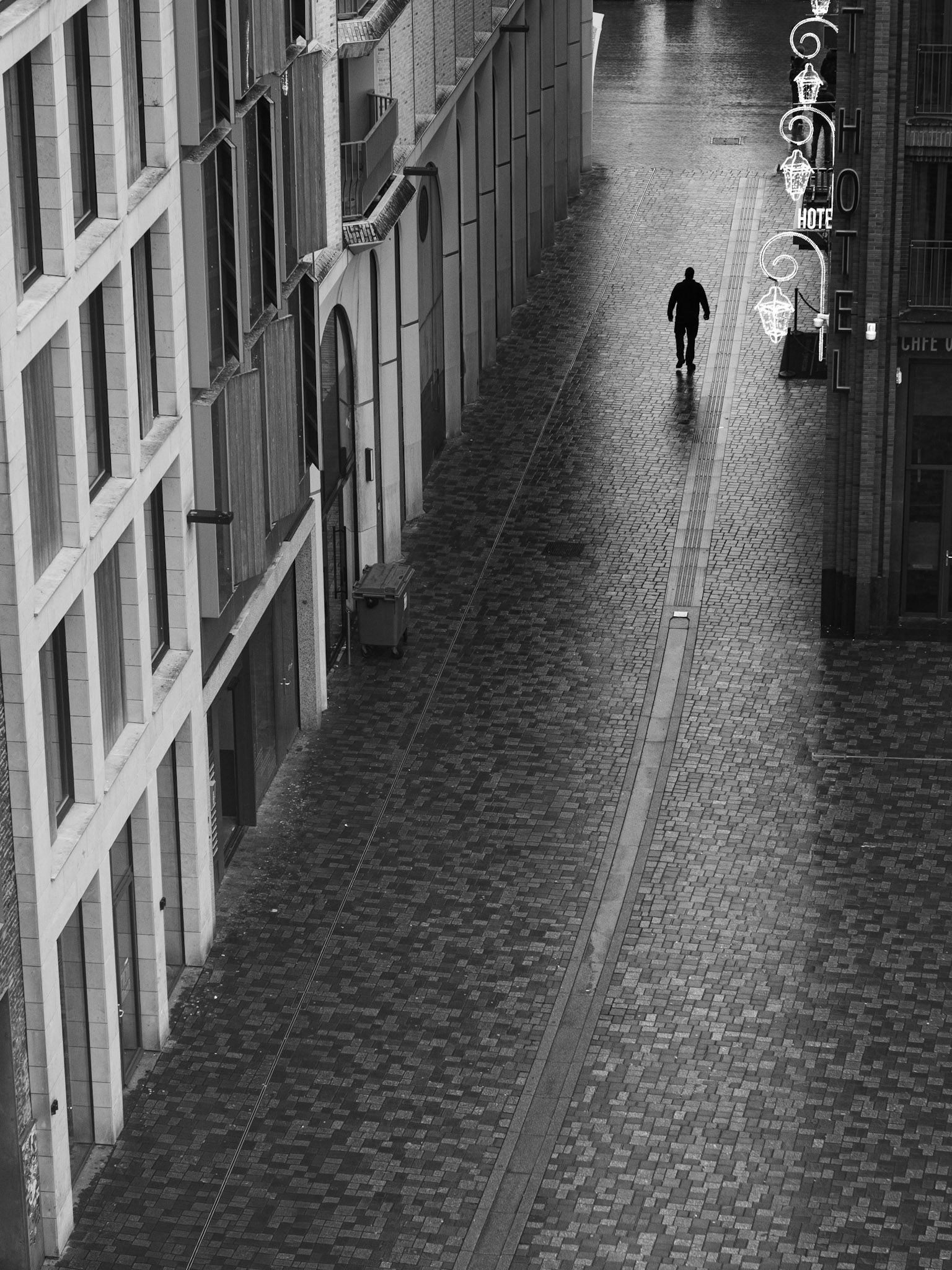 Eenzame wandelaar in de natte arcade: lijnen naar oneindig.