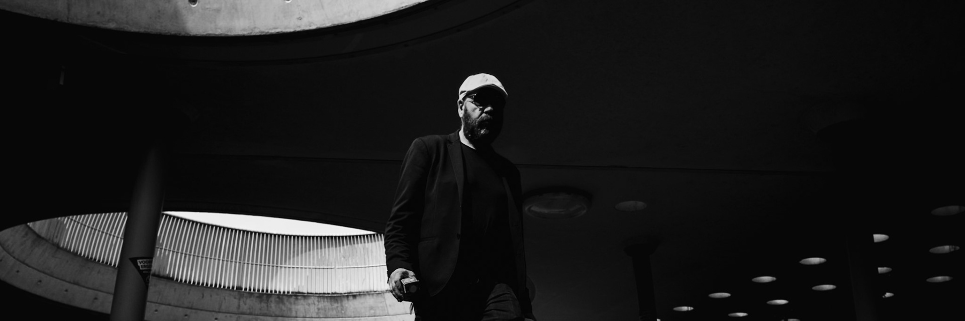 Hij stapt vooruit, beton buigt om hem heen.