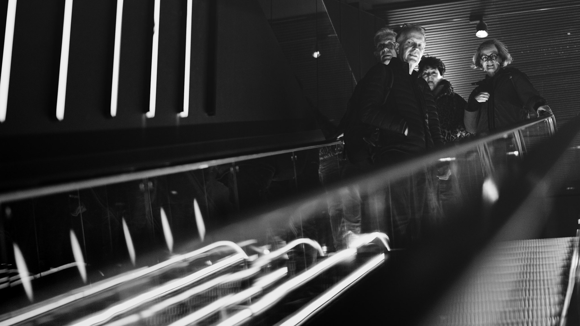 Ze escaleren synchroon omlaag, schaduwen trekken lang – Tarantino-esque.