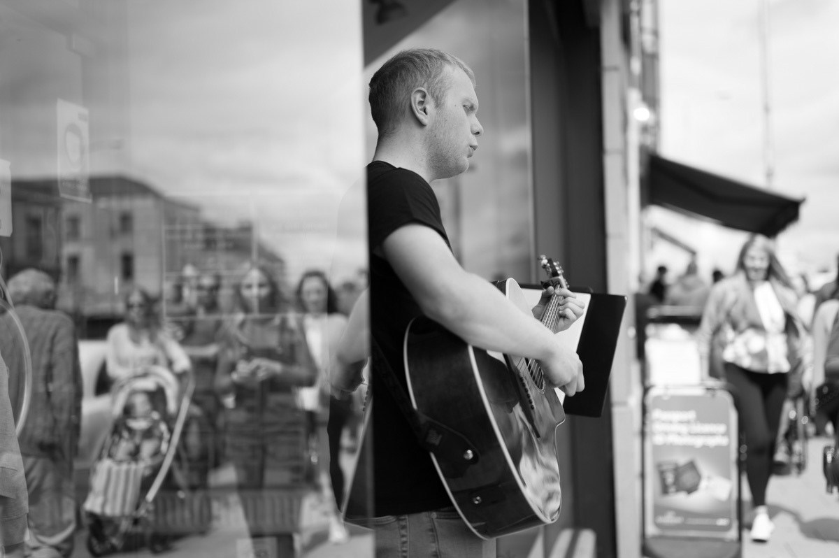 musician playing at shop front