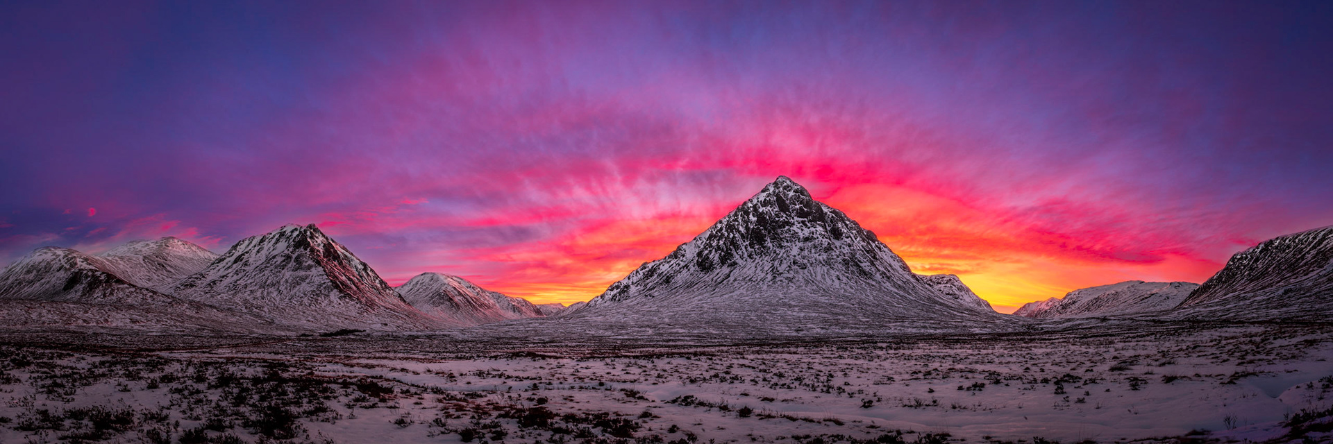 Clouds above Buachaille Etive Mor in Glen Coe, Scotland, are lit up by the afterglow of the setting sun.