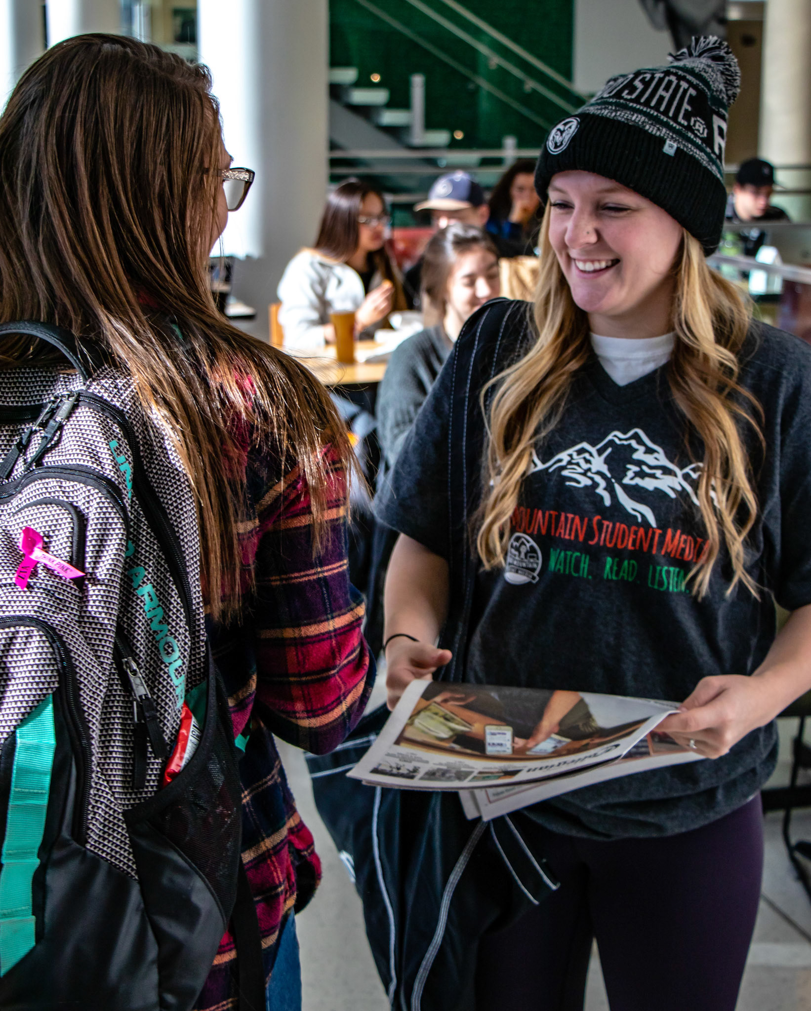 The purpose of this photo was to illustrate that with every printed version of the Collegian, there are friendly volunteers to hand you your copy.