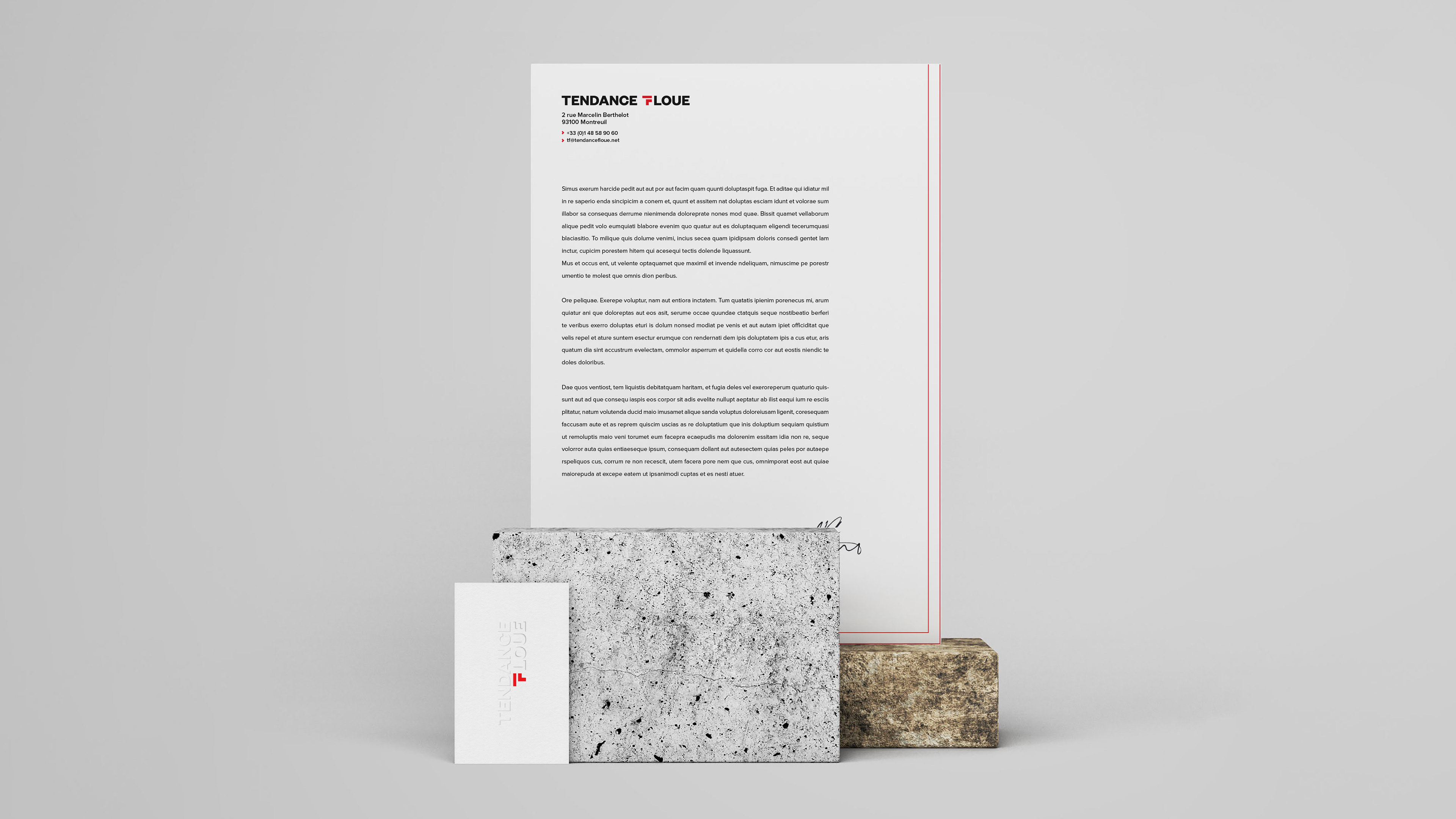 Letterhead standing on a stone block with vertical business card next to a stone block
