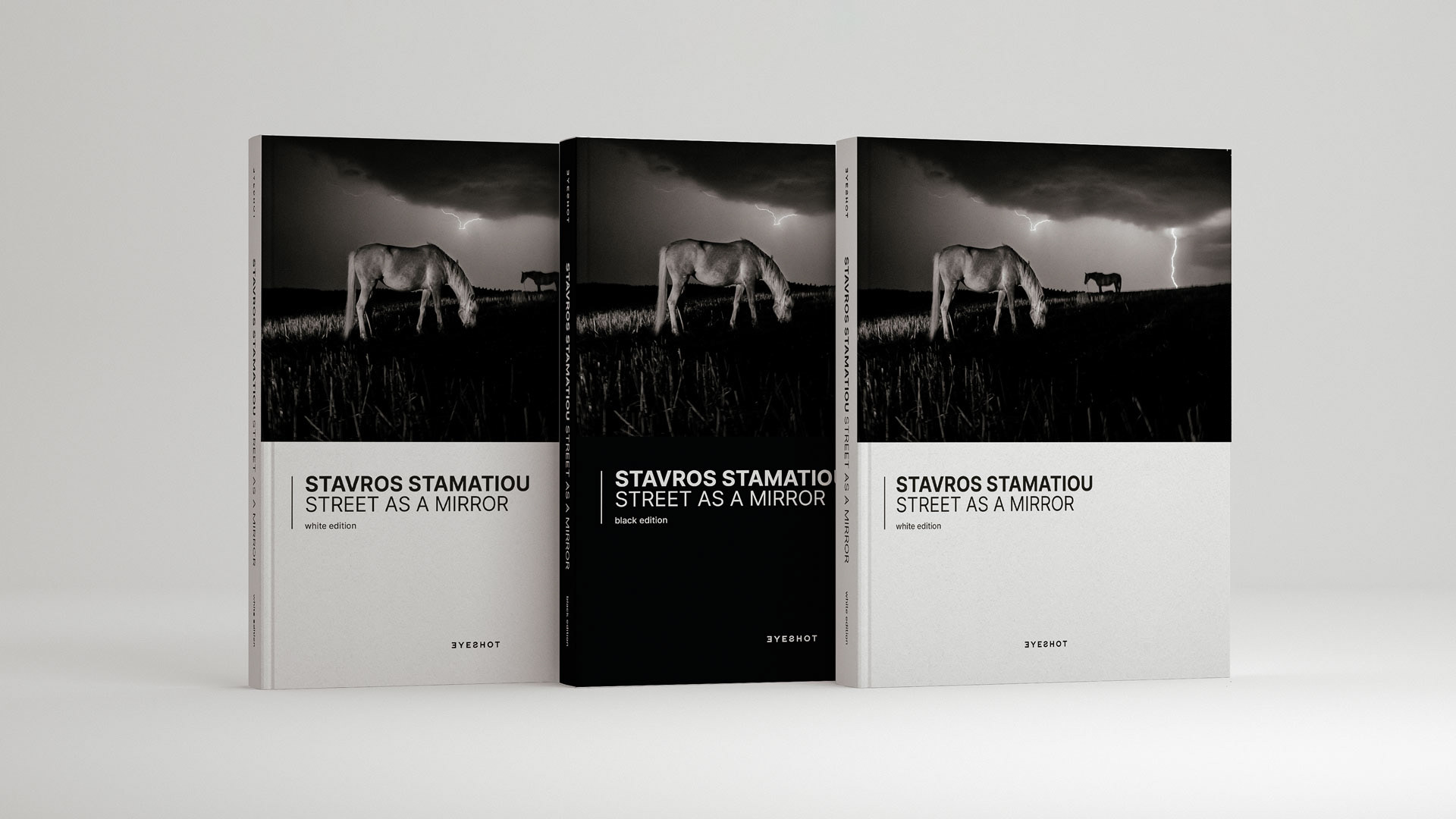 Three aligned books with two white edition covers and one black.