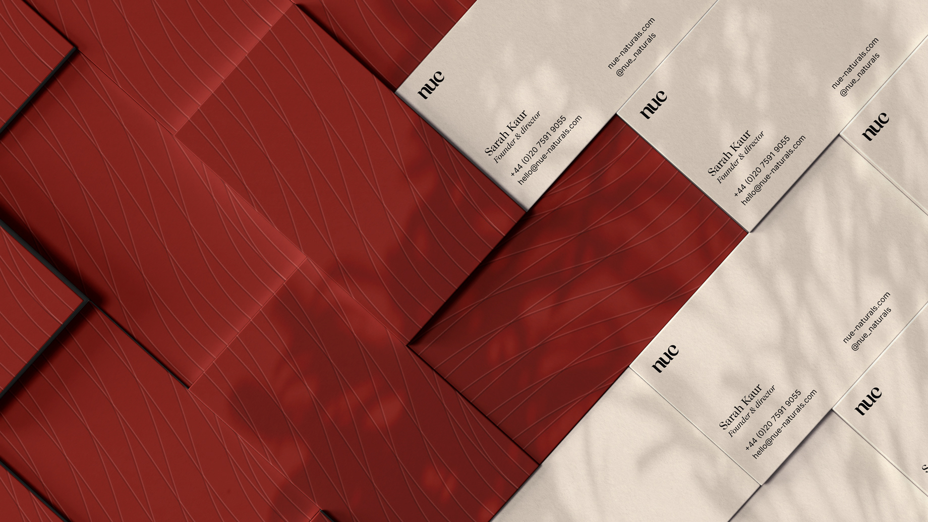 Red business cards with pattern embossed on the front and logo, contact infos on the back