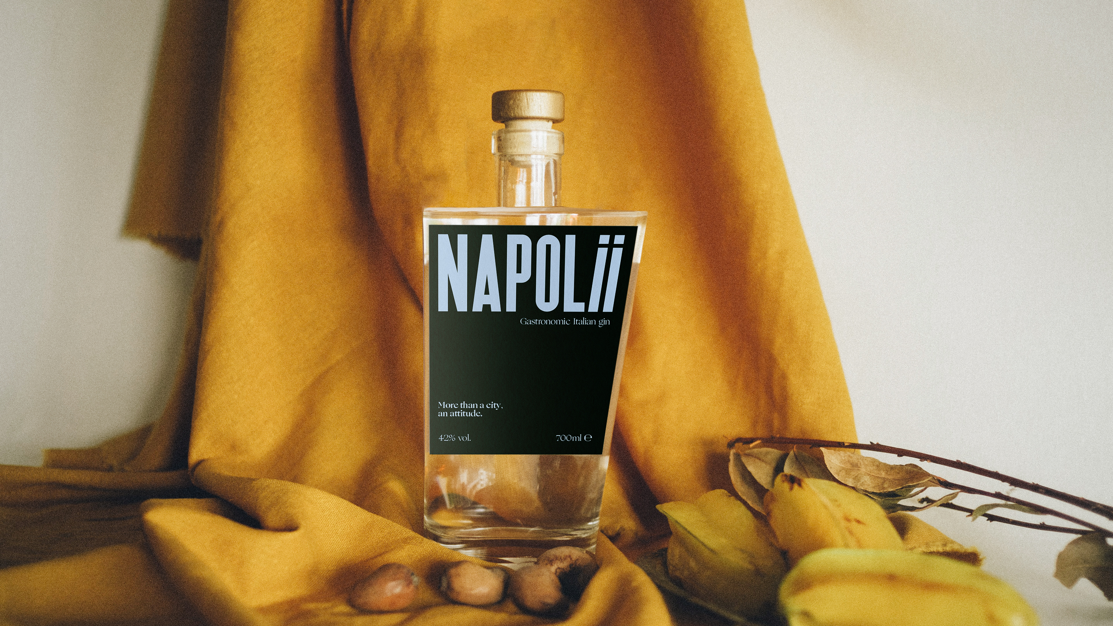Bottle of gin in front of a beige drape