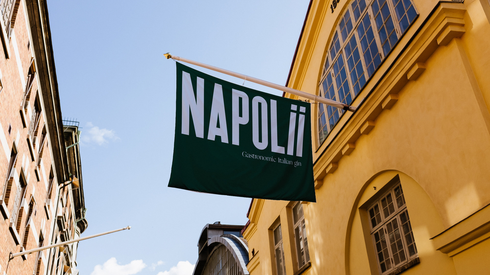 Dark green flag with blue Napolii logo on a building front