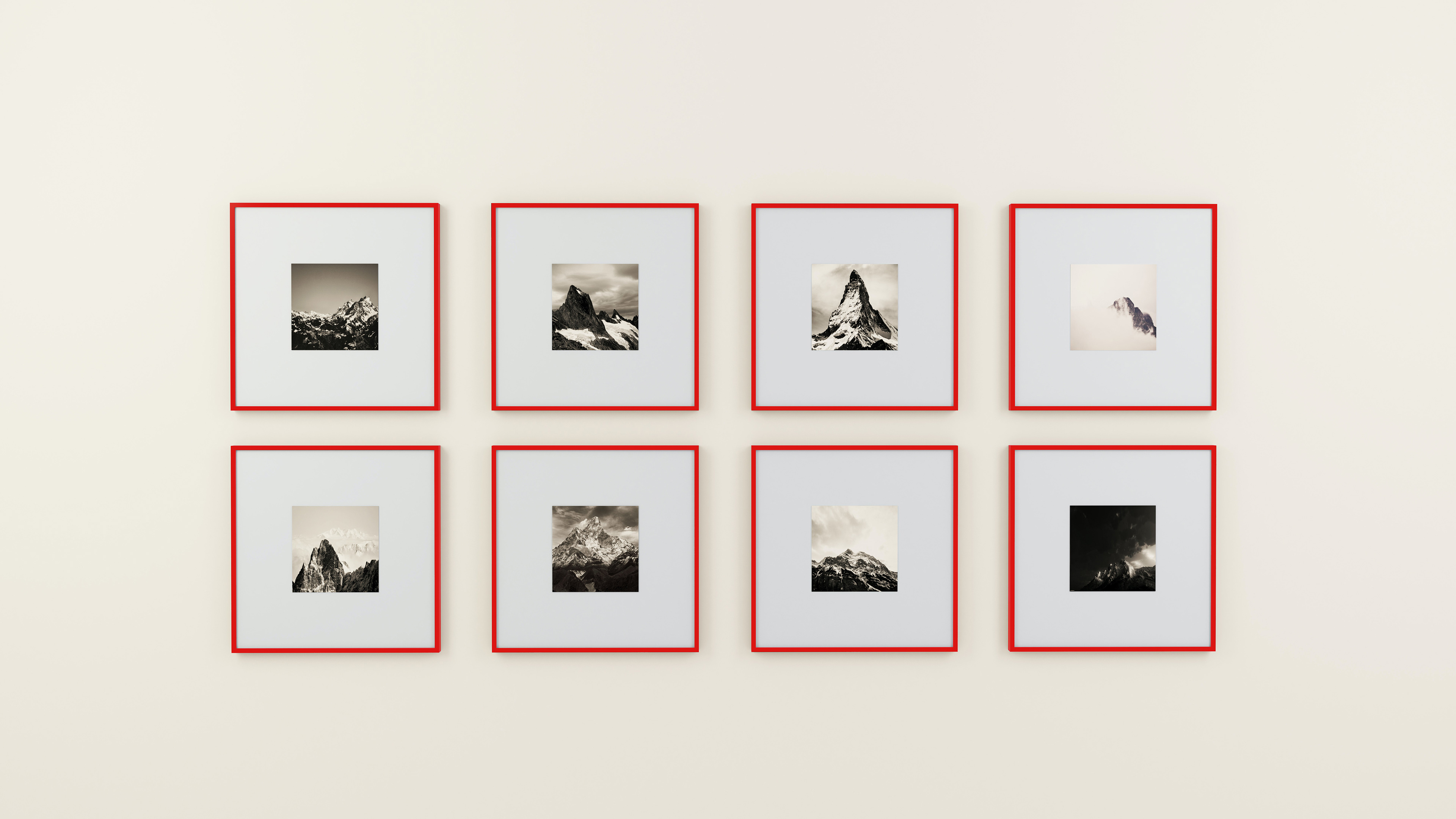 Six black and white photographs in red frames on a white wall