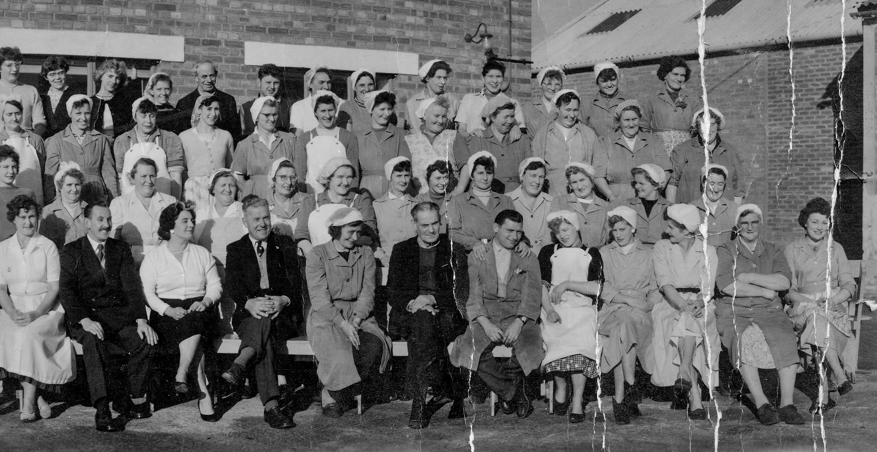 1959 Goldhanger Fruit Farm employees and staff. Front row L-R:?, ?, Olive, ?, ?, ?, Jack? Clarke, Amelia Kempen, ?, ?, ?, Doreen Cottee. Third row fifth from left: Maggie Seaborn. Back row L-R: Audrey Bridges, ?, ?, ?, ?, Brian Lawrence. (Courtesy Karen Tuke, Tolleshunt Major in Words and Pictures old Photos on Facebook)