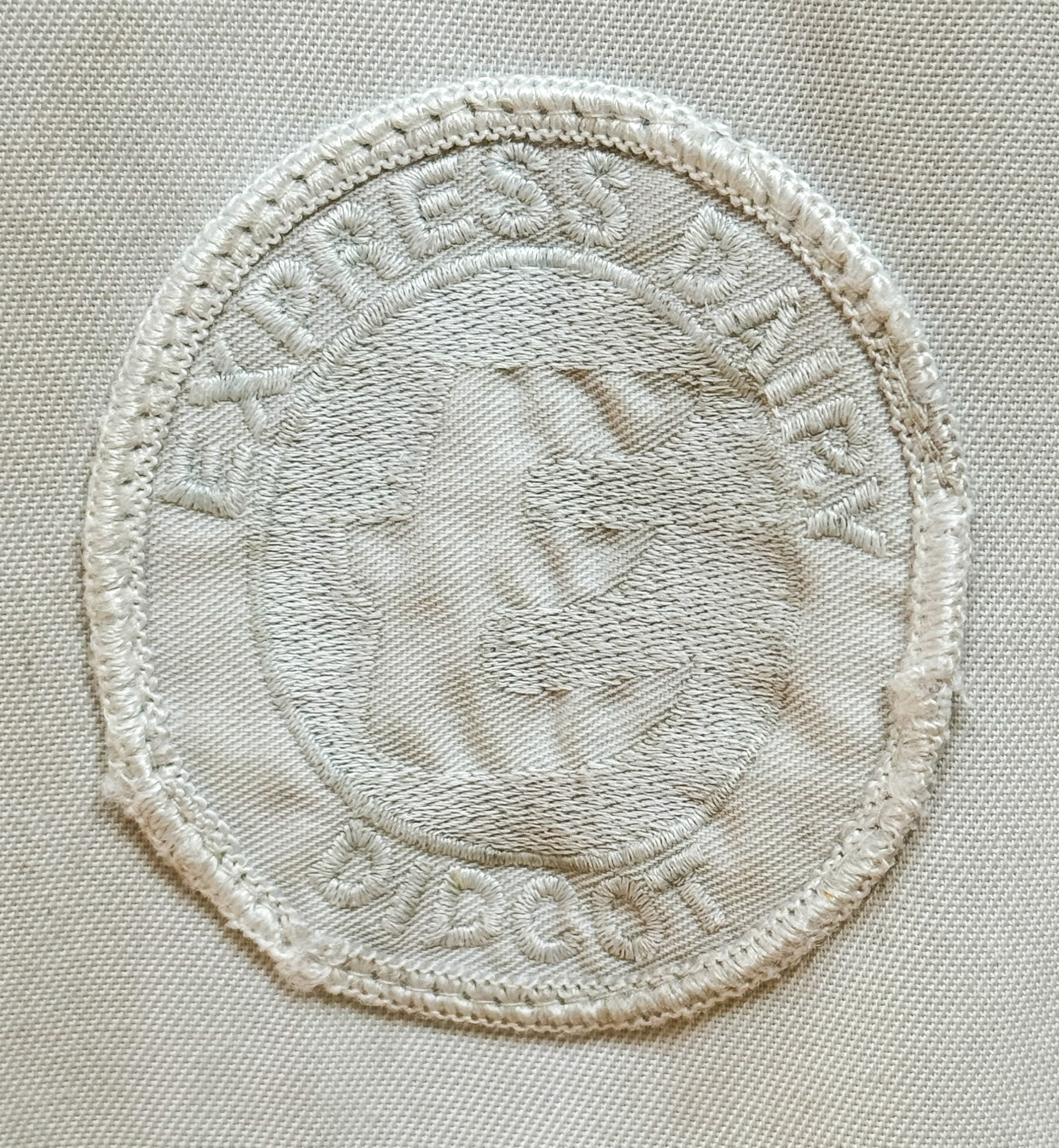 2024 Badge Detail from a white lab coat. (Didcot Dairy Exhibition 2024, Cornerstone Arts Centre)