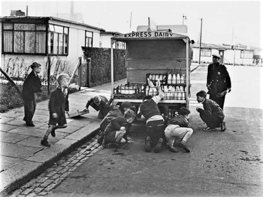 1950's Express Dairy Milk float 'ambushed' in by a gang of young boys near some prefabs in the Battersea area.