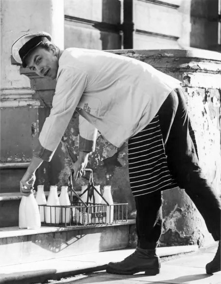1950's? Express milkman making a delivery "A cheerful milkman puts the requisite number of milk bottles onto the doorstep."