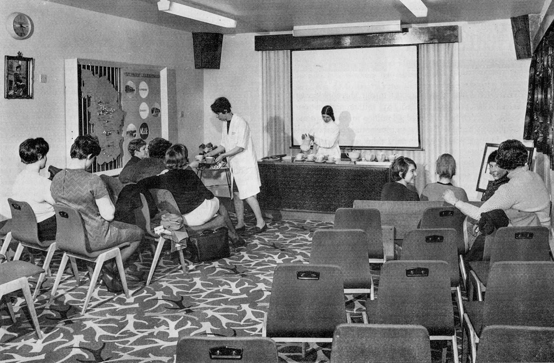 1968 Wakefield. Tea in the Visitors' Room for a group of nurses from Snapethorpe Hospital. Complete with built-in cine projector, the room is in use most days and Lab Supervisor Nancy Oldroyd (handing round the cups) answers a barrage of questions on health and hygiene with Elaine Rodgers in the background. (Express News Summer)