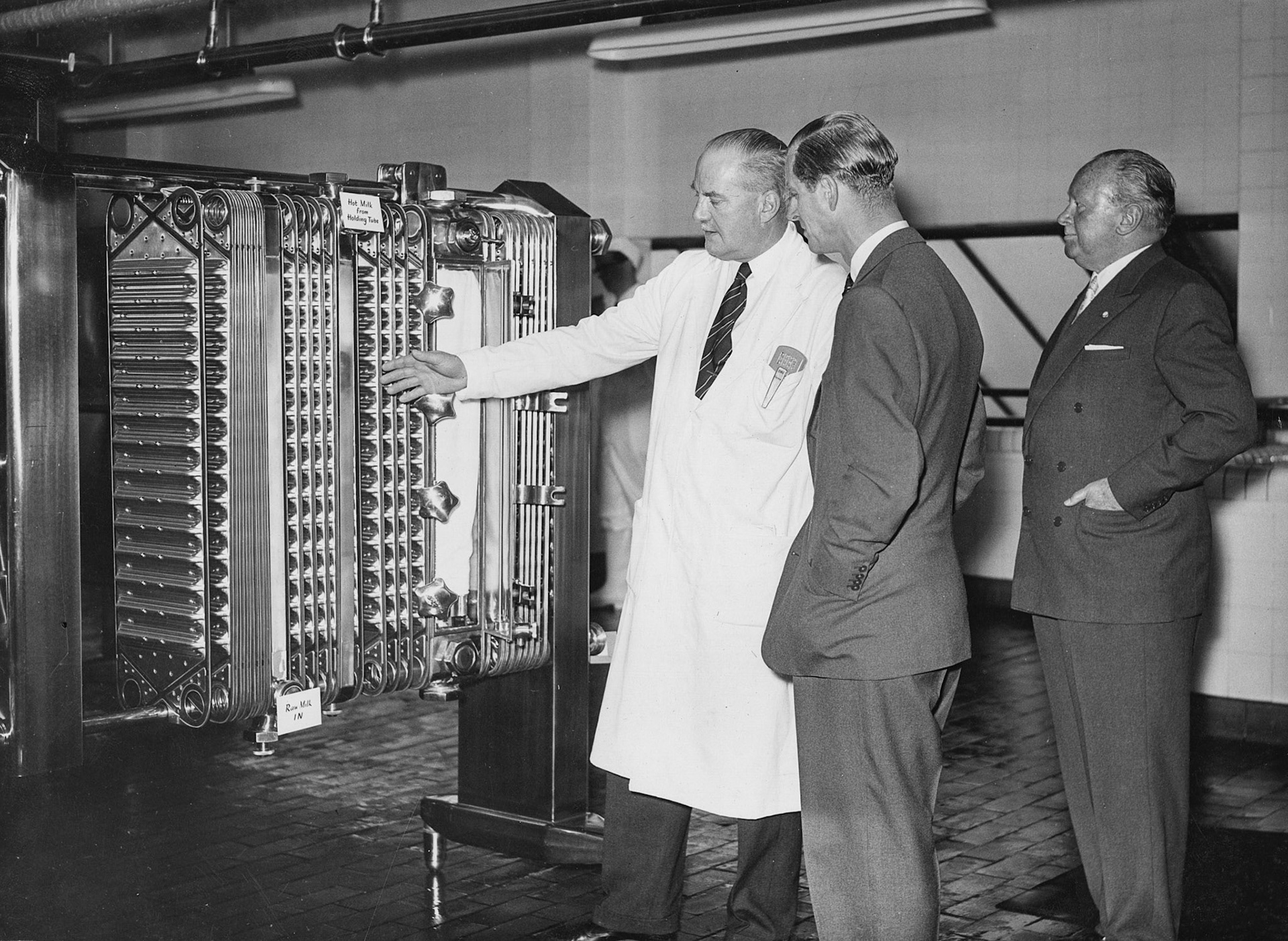 1957 South Morden-Duke of Edinburgh's visit on November 12-Mr T.D, Potter Processing Director explains the operation of a pasteuriser to the Duke, with Walter Nell looking on (Courtesy Paul Luke)