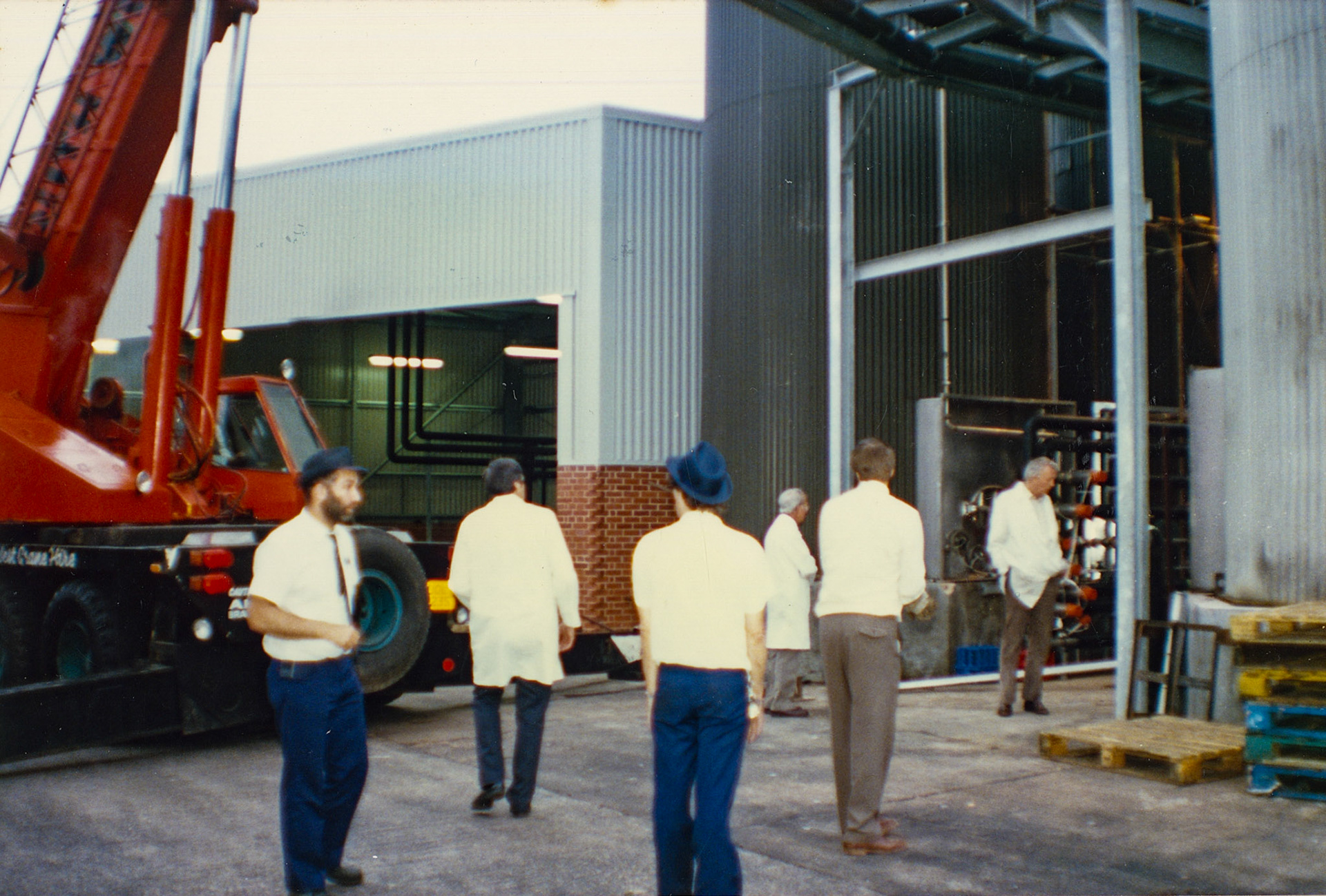 1980s Exeter Processing-silo and milk reception construction. Phil Howe on the left, Terry Horton (Technical Services) with his back to us (2), Steve Evans in the blue trilby (3) possibly George Streeting (4) and Bernard Wilton, also Technical Services with his hands in his pockets (6). Jimmy Reid tells the story "Bernard Wilton could identify various strains of manure whilst driving his car from Ruislip to Exeter, went with him on one occasion. He would say something along the lines of: mmmm pigs, or aha cows and then OOOOOH NO! Chicken shit!!!!!😂 priceless." (Pictures by Syd Johnston, presented by his son Ian via Teresa Heal)