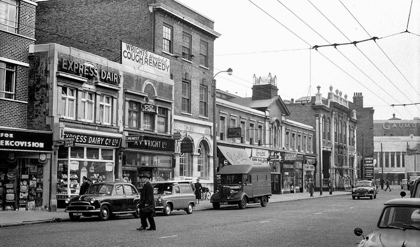 1950's Express Shop in Queen Caroline St, Hammersmith Broadway, prior to the construction of the flyover. Gaumont Cinema in the background, trolley bus power lines still in use. (Courtesy Robin Fraser Bell,)