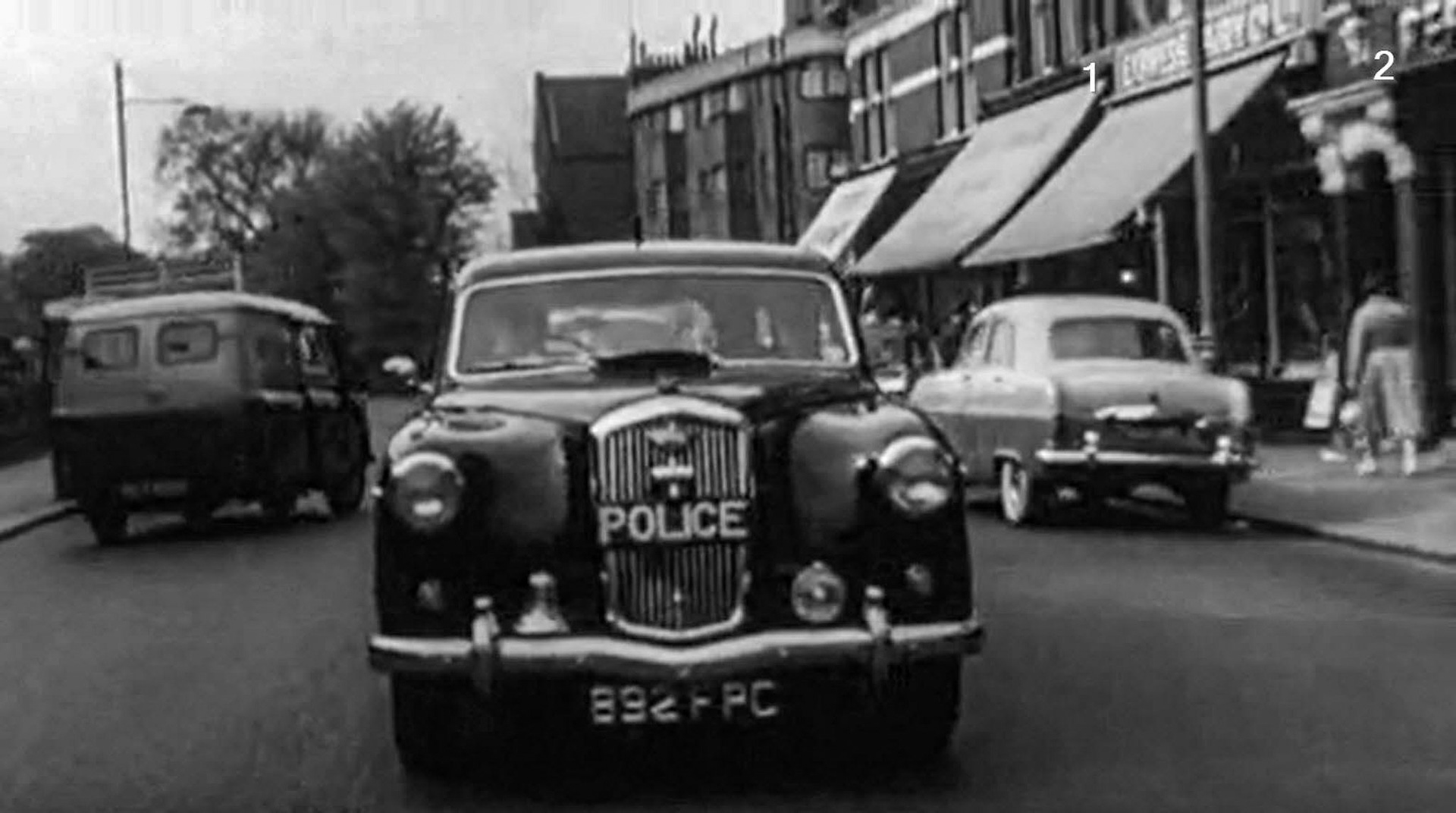 1960 Ealing shop and depot, still from film 'Carry On Constable'. Ann Hughes says "Express Dairy was at 48 'The Mall' from 1929 - 1972." Ila Cunningham comments "I had a friend, Penelope, who lived in the flat over the Express Dairy shop, and there was a cobbled yard behind; the horses were kept there I think. I also had boyfriend Barry who worked on weekends in the garage approached through an alleyway near the dairy and from another driveway off Florence Road." Paul Chapman adds "Worked there as a milk boy in 1960. Shop on 'The Mall' on the corner of Northcote Avenue with the depot around the back where all the milk floats were housed." Martyn Mellersh remembers "I helped Fred at weekends who was a milkman there in the early 60's. Fred had a electric hand cart and his round was Windsor Road, The Grove and Florence Road. Main entrance was in The Mall near the newsagents with  another entrance in Florence Road. My pay was a packet of Lincoln biscuits and a bottle of orange juice. And we would go in the cafe opposite the toy shop for tea and toast. Fred would go down the road and yodel to let customers know we were coming." (Courtesy Alan Bourke)