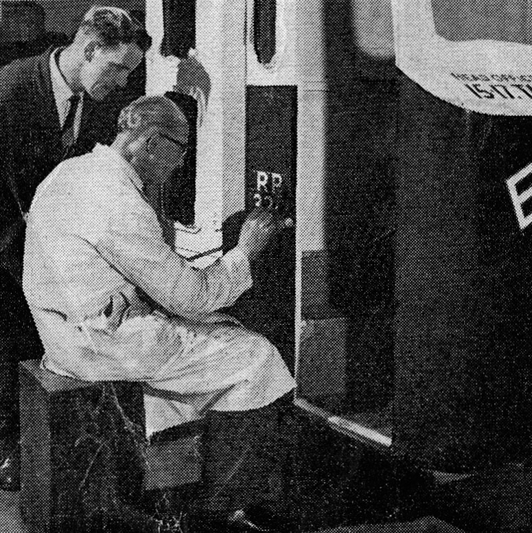 1958 Senior Sign Writer Mr Bill Jackson gets on with his exacting work under the eagle eye of Mr Ted Cain, the Paint Shop Foreman'. (From Express News 1958-September)