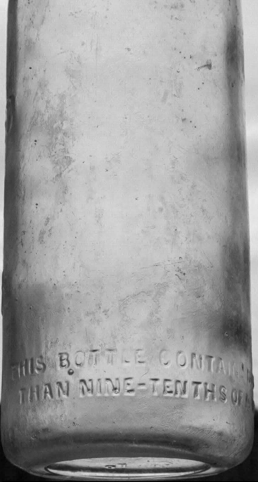 1920s sterilised pint milk bottle embossed with: "THE SURREY STERILIZED MILK CO, SOUTH LAMBETH,S.W.8. On the reverse side near the base: "THIS BOTTLE CONTAINS NOT LESS THAN NINE-TENTHS OF A PINT. William Davis comments "Originally it would have been sealed with a porcelain swing stopper attached by a wire bail. The Surrey Sterilized Milk Co. was based at Nine Elms and was acquired by Express Dairy in the early 1960s." (Courtesy William D.T. Davis)