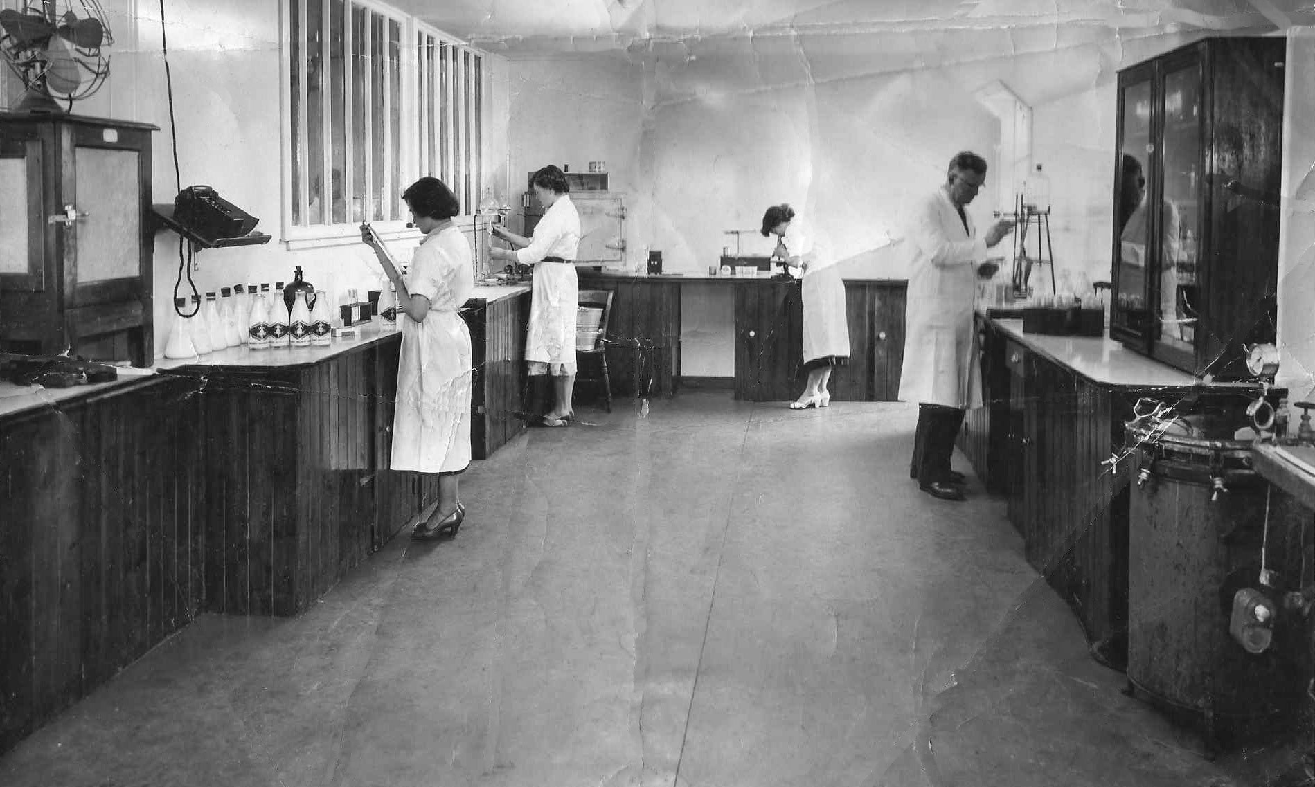 1960's early. Kilmaurs Creamery Laboratory. John Miller comments "My Grandfather and mother are at the back on the left-Charlie and Hope MacConnachie. He told me that he was checking his starter activity for the next day". (Courtesy John Miller)
