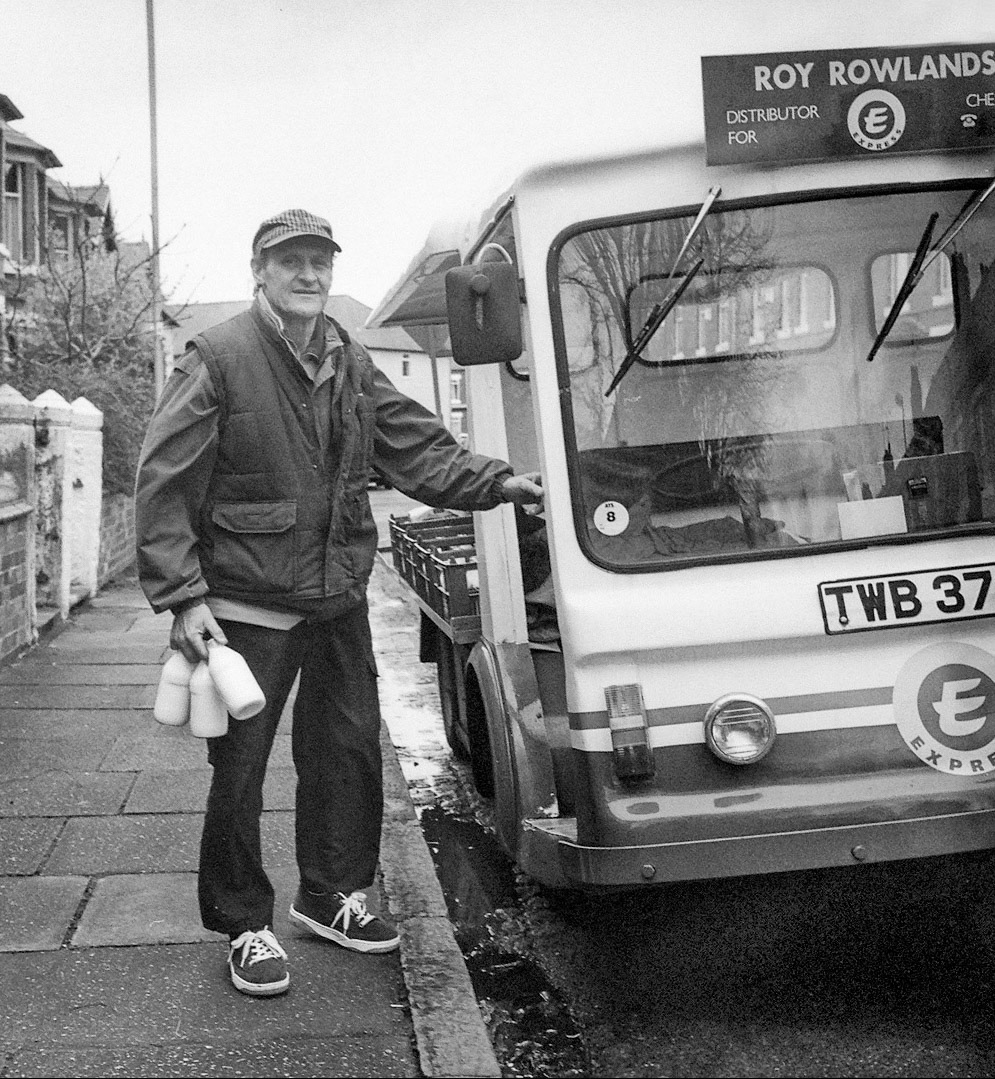 2000 Chester milkman Roy Rowlands delivering in Hoole, Chester. "With the recent passing of legendary Hoole milkman Roy Rowlands, I thought it fitting to repost this photograph I made of him in Lime Grove as part of the Millennial Hoole Heroes Project, when local children voted for their favourite adults. The pictures were displayed in All Saints School on Clare Avenue. Gwyneth Cooper "A great photo of Roy. He was a much loved neighbour and he, and his dancing dog!, will really be missed by us all 😢". John Sanders "RIP Roy, I loved working with you as a milk boy 1978-81 and you ran over my foot 😂". Lynn Evans "Roy was my milkman for many years when I lived on Hoole lane, what a really nice guy-always had a kind word and a smile, got my Christmas hampers every year off him for me and my boys. RIP kind man ❤️ xx". Gill Jackson-Haynes "Yes I remember Roy, so sorry to hear has passed. He was one lovely genuine fellow. He delivered to our family house in Pine Grove, Hoole. Let me sit on his milk float when I was coming home early morning from night out on the town. 😜". Karen McNicholas "Our Col and Dave worked on the milk round with Roy, after the round they had a hearty breakfast at my nans every weekend, he was part of our family." (Courtesy Chester: a Virtual Stroll Around the Walls FB Group)