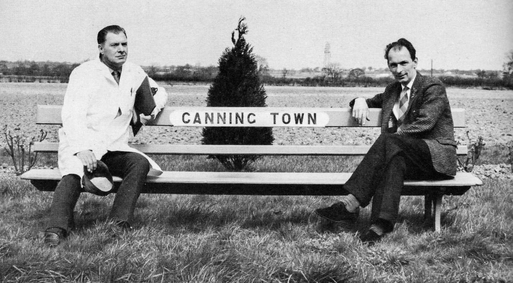 1969 Lee Morrison comments "This seat was outside the Goldhanger Fruit Farms' canning plant. At peak periods, the factory despatched 4 million cans a week, The canning plant had 88,000 square feet of space, enough to hold a million packing cases of canned food. They also had space for 4,600 pallets at Tiptree. 70,000 to 80,000 cases were despatched all over UK each day. 89,000 tons of tin plate was used to make each year's cans. Rita Butterfield and Lee Morrison identify the man in suit as Dennis Lee,  the other man is Eric Warrener. The sales director, Harry Mendoza, got hold of this original Canning Town bench." (Courtesy Lee Morrison)