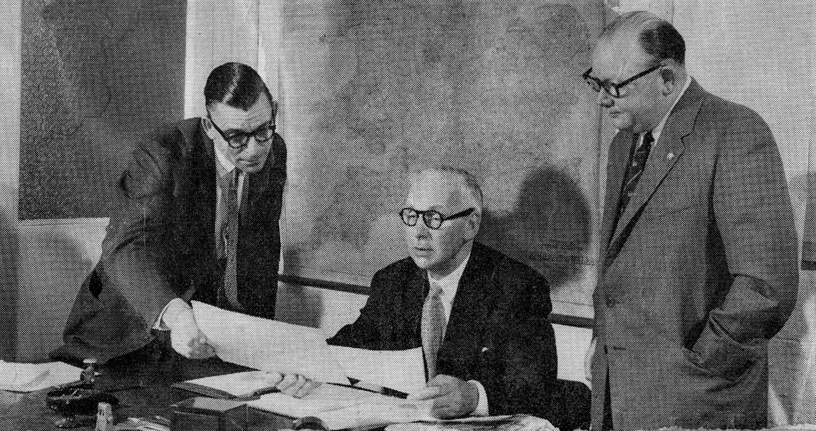 1958 Flanked by his fellow directors, Mr D. Mills and Mr G. R. Gervis, Mr Walter Reeves thumbs through a collection of old photographs and talks about the old days, when T. H. Lewis went in for coach building. (From Express News 1958-September)
