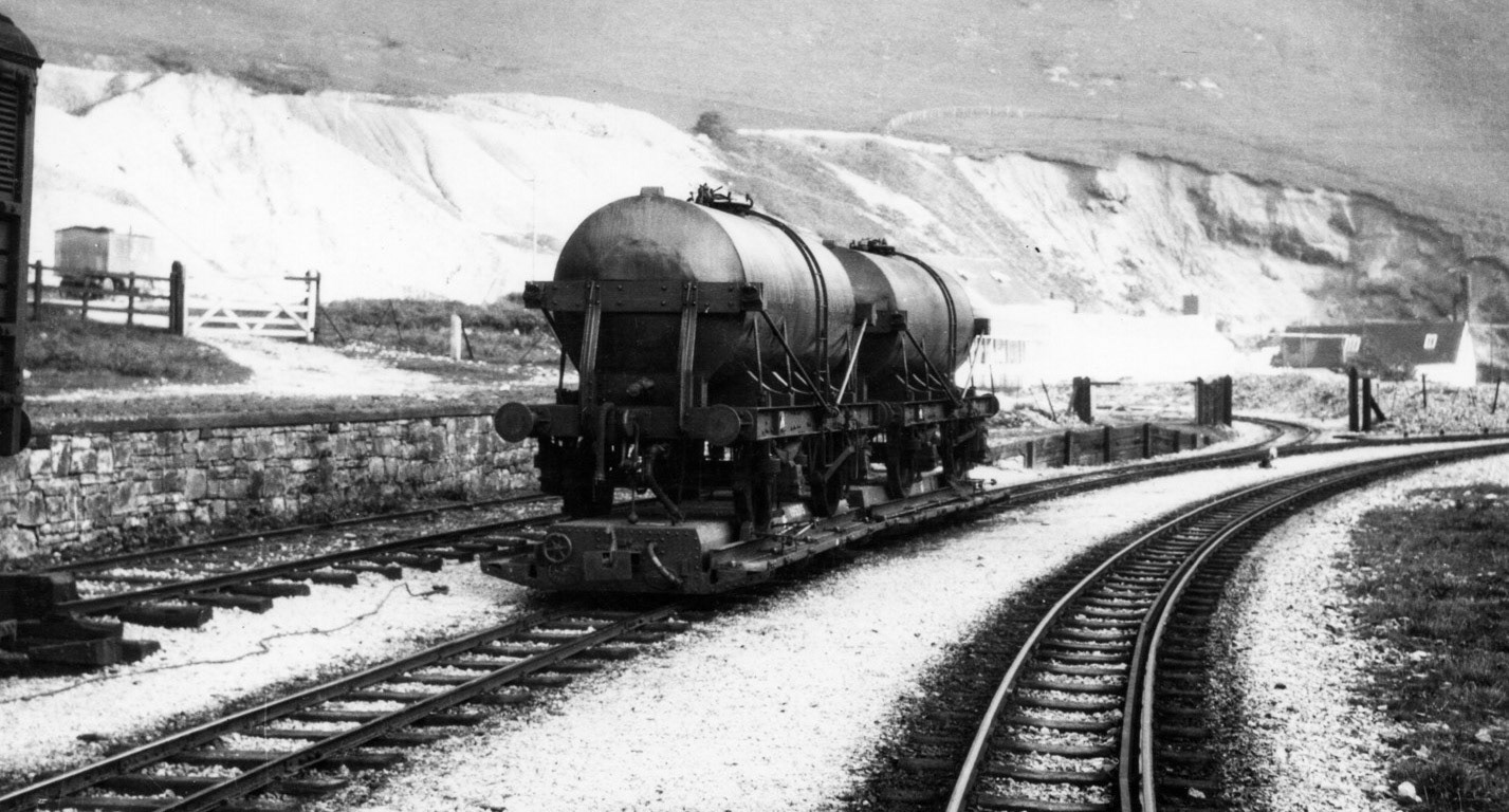 1930's Mainline gauge rail milk tanker at Ecton on a narrow gauge transporter wagon. Alan Salt comments "Farmers and contractors would bring milk to Ecton, some may have been used to make cheese but when excess milk was available (or when liquid milk was worth more to the Company) these tankers would take the milk to Waterhouses then on to Manchester or London. Wilts United Dairies, who ran Ecton, were doing similar at their Uttoxeter site and these rail tanks could well end up at Uttoxeter for onward travel." John Irish adds "I think these tankers were attached at Uttoxeter to the London milk train and then travelled to the large dairy at Finsbury Park." (Courtesy Alan Salt)