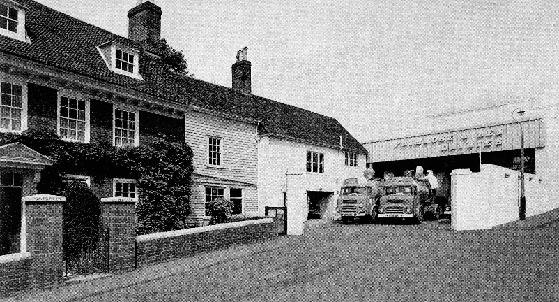 1965 Primrose &amp; Len's head office in Lower Stone Street occupies what was once the garden of the early Georgian house on the left. Milk, delivered by bulk farm collection tankers, is bottled on site and distributed among 50 retail rounds. Dee Hatcher comments "My dad worked for Charles Arkol, that started off with a small yard there.", David Naghi comments "I helped the milkman before I went to school.". John Hakeman remembers "... school milk in 1/3 pint bottles, hot and creamy but rank in the summer sun, ice lollies in winter! On the corner of Romney Place and Stone street-the milk bar, and milk machines all over Maidstone". Betty Davies asks "Who remembers the ice cream parlour on the corner?", Kathleen Stone replies "Yes, The Milk Bar. Delicious ice cream, served from the side window." (Express News Summer/Autumn)