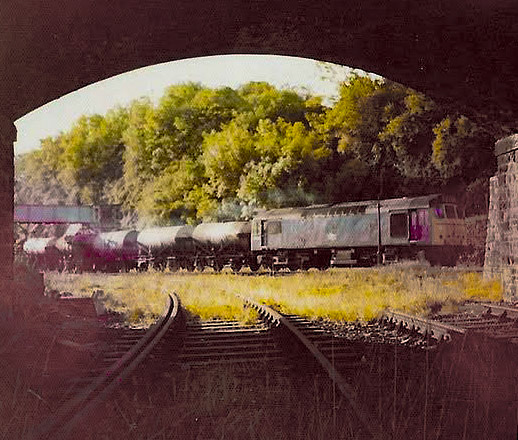 1970s? British Railways Sulzer 25153 leaving with the empty milk for Torrington. Matt Wood comments "taken from the track bed of the Ilfracombe branch, under Sticklepath Bridge. The Milks disappeared from Torrington in 1978, and on the western main line from 1980." (Courtesy Ken Baker, North Devon Railways FB Group)