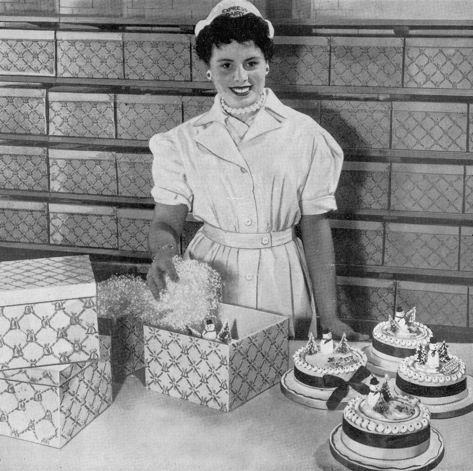 1956 Drayton Park Bakery-Miss June Williams parcels up a cake for Christmas. (Express News Front Cover, December)
