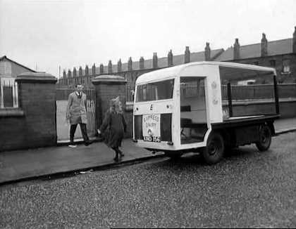 1965 film "Cup Fever". "Children from Barton United are trying to win the local league cup but a local Councillor does his best to ensure that his son’s team wins instead. Skipper and Rocket talk as they help deliver milk. (Naysmith Road in Eccles, with Roby Road and high rise blocks off Cawdor Street in the background.) Rocket delivers more notes advising of the location of the next match. (Shaftesbury Avenue in Eccles) The milkman is asked to help. (Parr Street at the entrance of Lewis Street School with the rear of properties on Renshaw Street forming the background.) A third milkman is asked to join the hunt. (Lewis Street in Eccles) The milkman drives Stopper to the ground. (Edison Road with Shakespeare Avenue to the left.) The floats come to a stand and the missing players rush towards the ground's entrance. (Golf Road with buildings on Moss Lane in the background.) From: https://www.reelstreets.com/films/cup-fever-childrens-film-foundation/