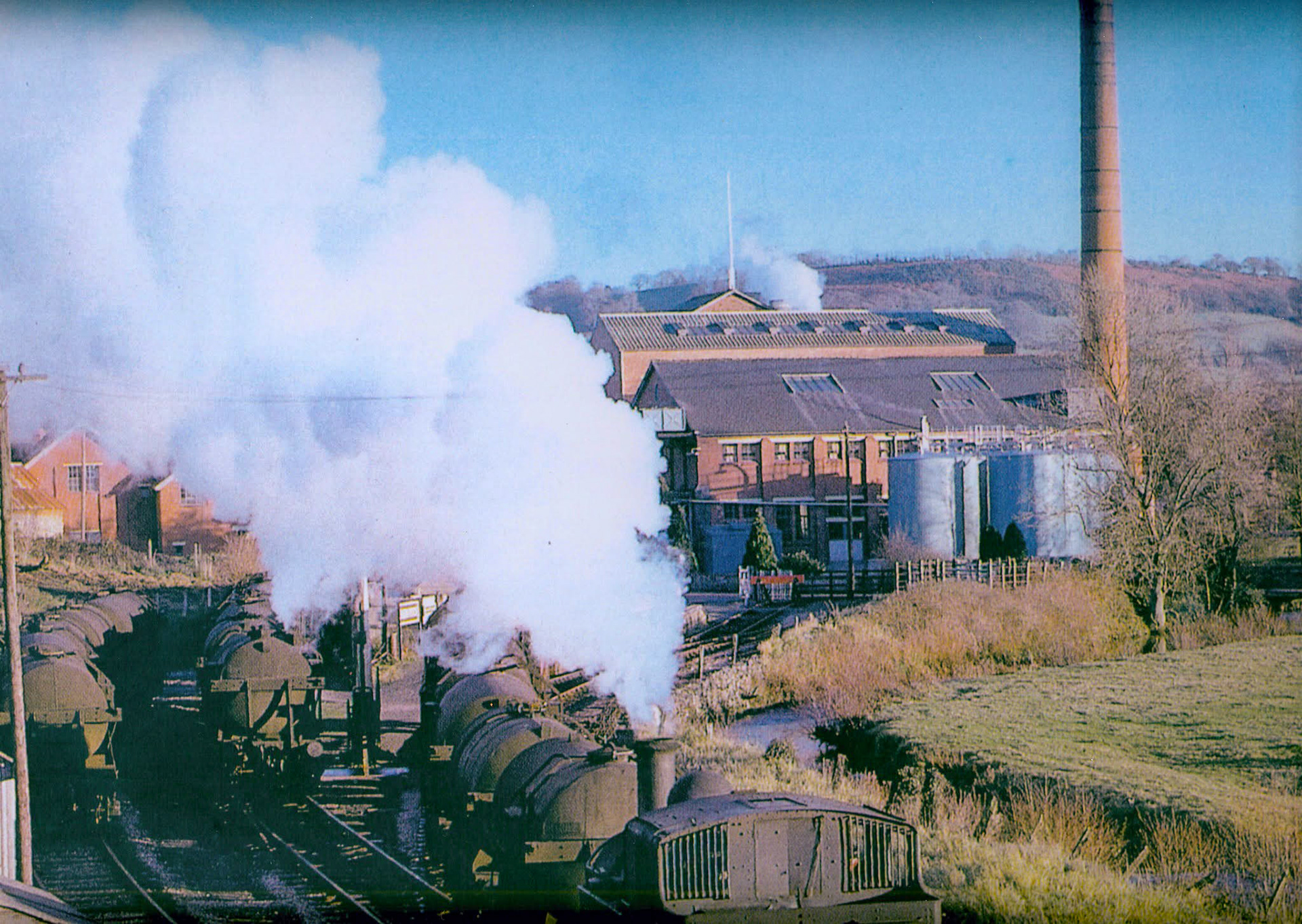 1960s? Hemyock, Devon-"A steam locomotive moves a rake of milk tanks, while several other milk tanks sit behind the station". Express only did egg packing at Hemyock, the dairy later became St Ivel." (Courtesy Discovering Devon, Somerset and beyond FB)