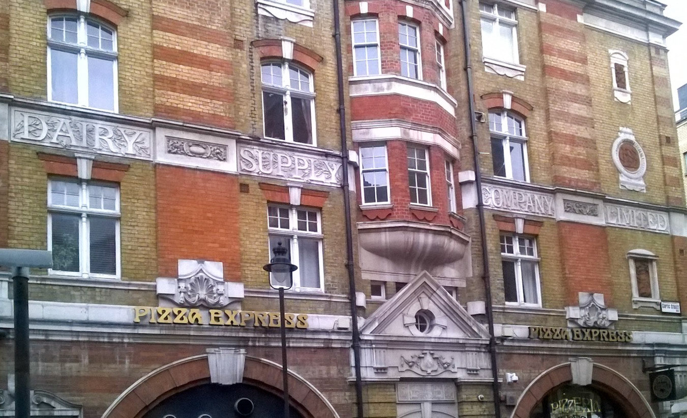 Dairy Supply Company (now Pizza Express) Architect: R.P. Wheelock. 1888. Location: 30 Coptic Street and Little Russell Street, WC1. Courtesy(Photographs and caption by Robert Freidus. Formatting and perspective correction by George P. Landow https://victorianweb.org/sculpture/architectural/92.html)
