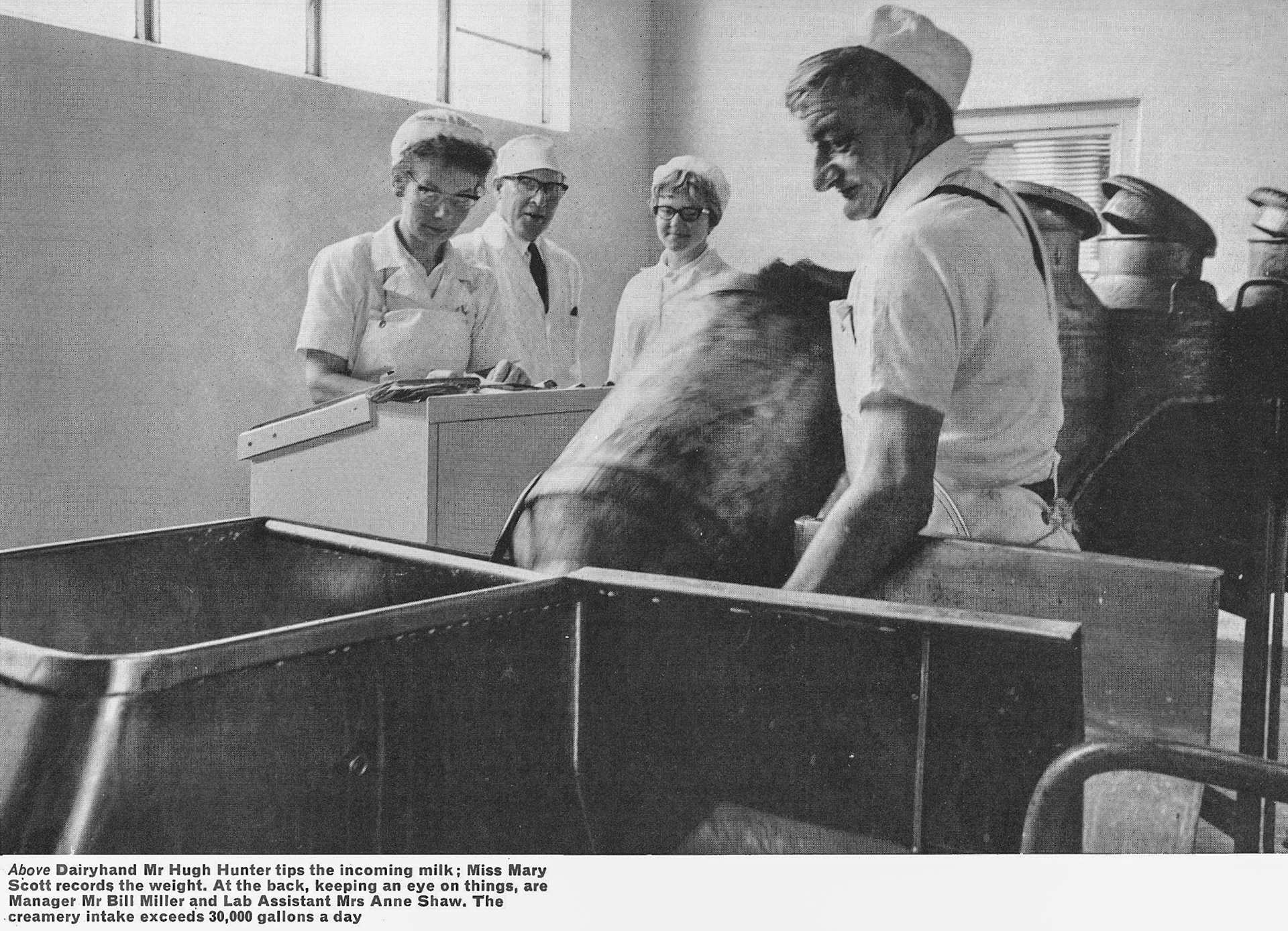 1967 Sanquhar Creamery. Dairyhand Mr Hugh Hunter tips the incoming milk; Miss Mary Scott records the weight. At the back, keeping an eye on things, are Manager Mr Bill Miller and Lab Assistant Mrs Anne Shaw. The creamery intake exceeds 30,000 gallons a day. Peter Scott comments "My Aunt Mary, the family all called her 'Mole'." (Express News Autumn)