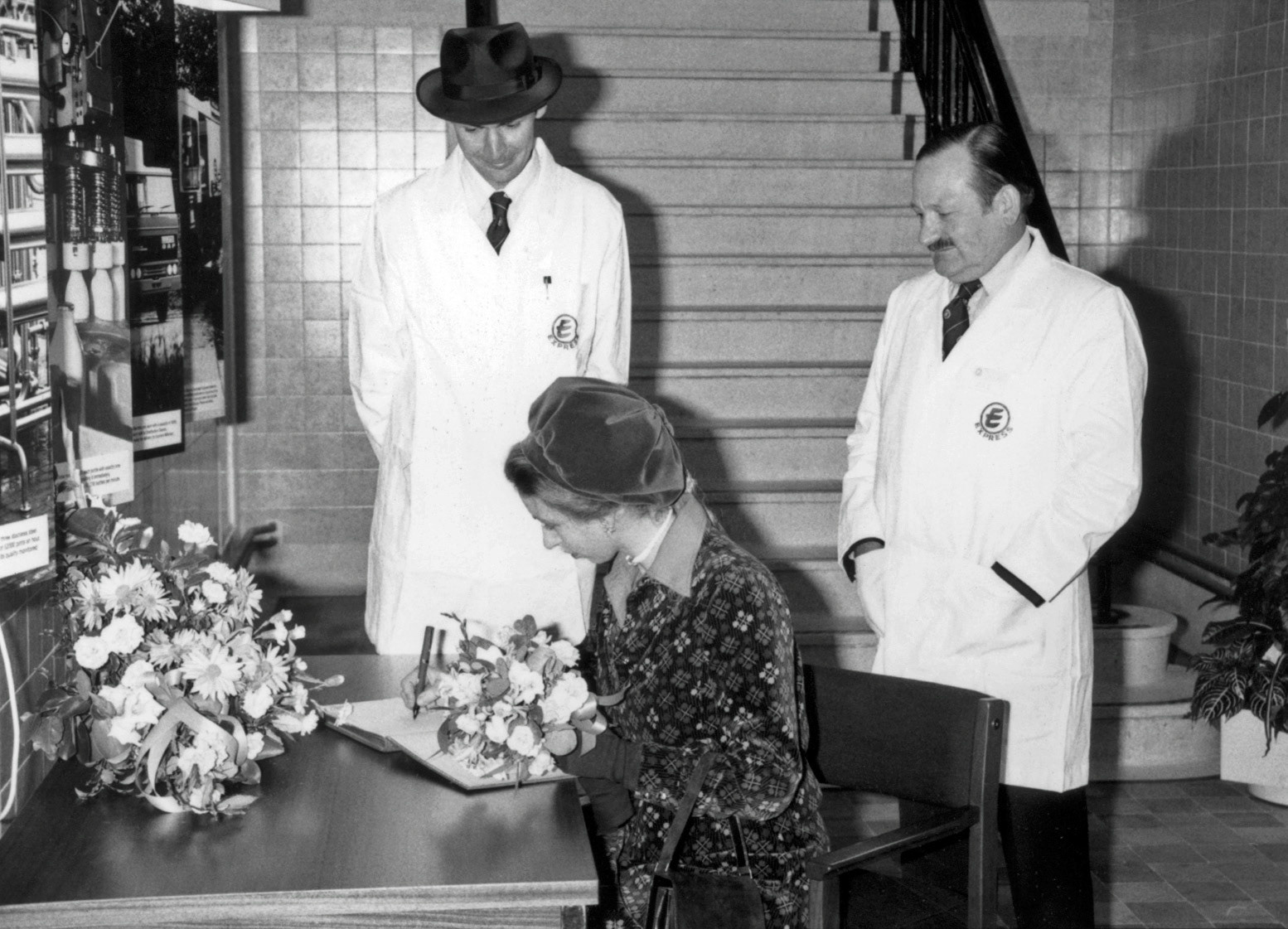 1980 Princess Anne, Peter Roper and Jim Hodges signing the visitors' book in reception before the tour