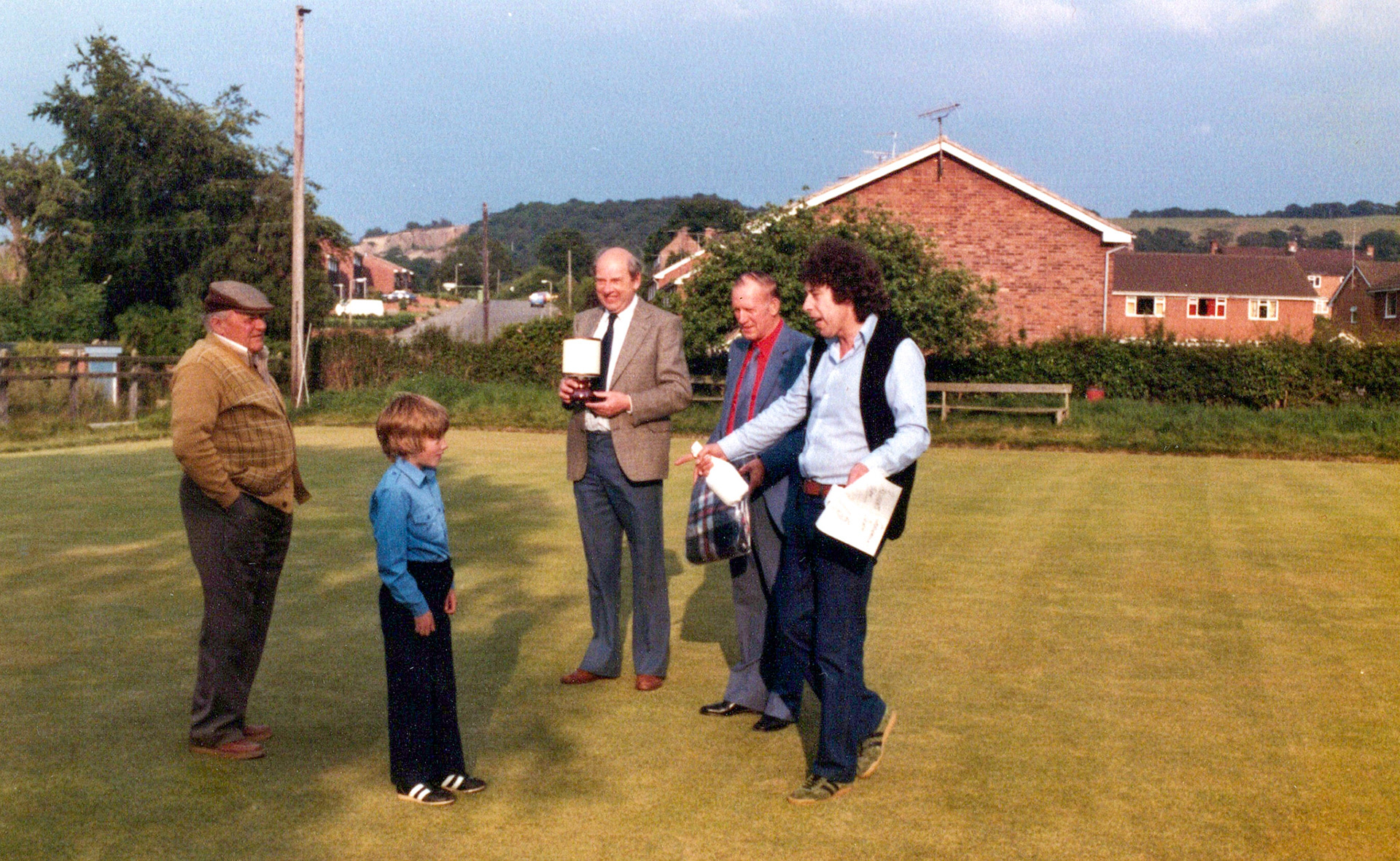 1980's Minsterley Bowling Club. Lavinia Morgan and Phoebe Spragg comment "Tony Bishton on the right". Kenneth Carswell identifies Jessy Rowson in middle, and Bert Evans on his right. Monica Corfield adds "Evan Ingram on the left." (Courtesy Joe Lyons)